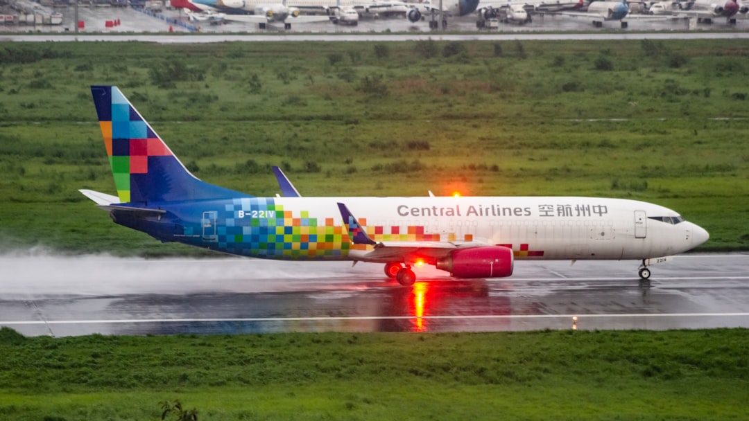 A colorful airplane landing on a wet runway,