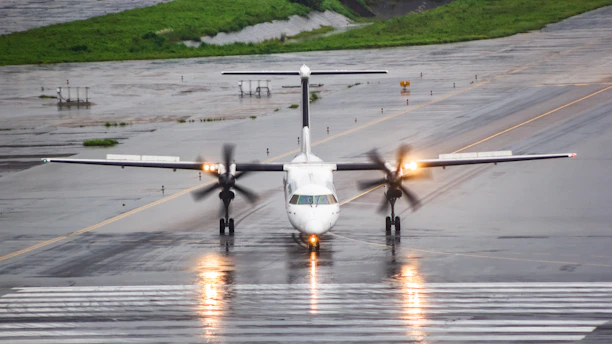 A small propeller plane on a wet runway