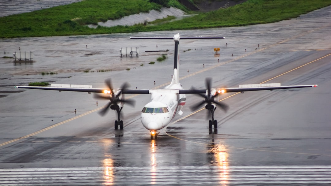 A small airplane is on a wet runway,
