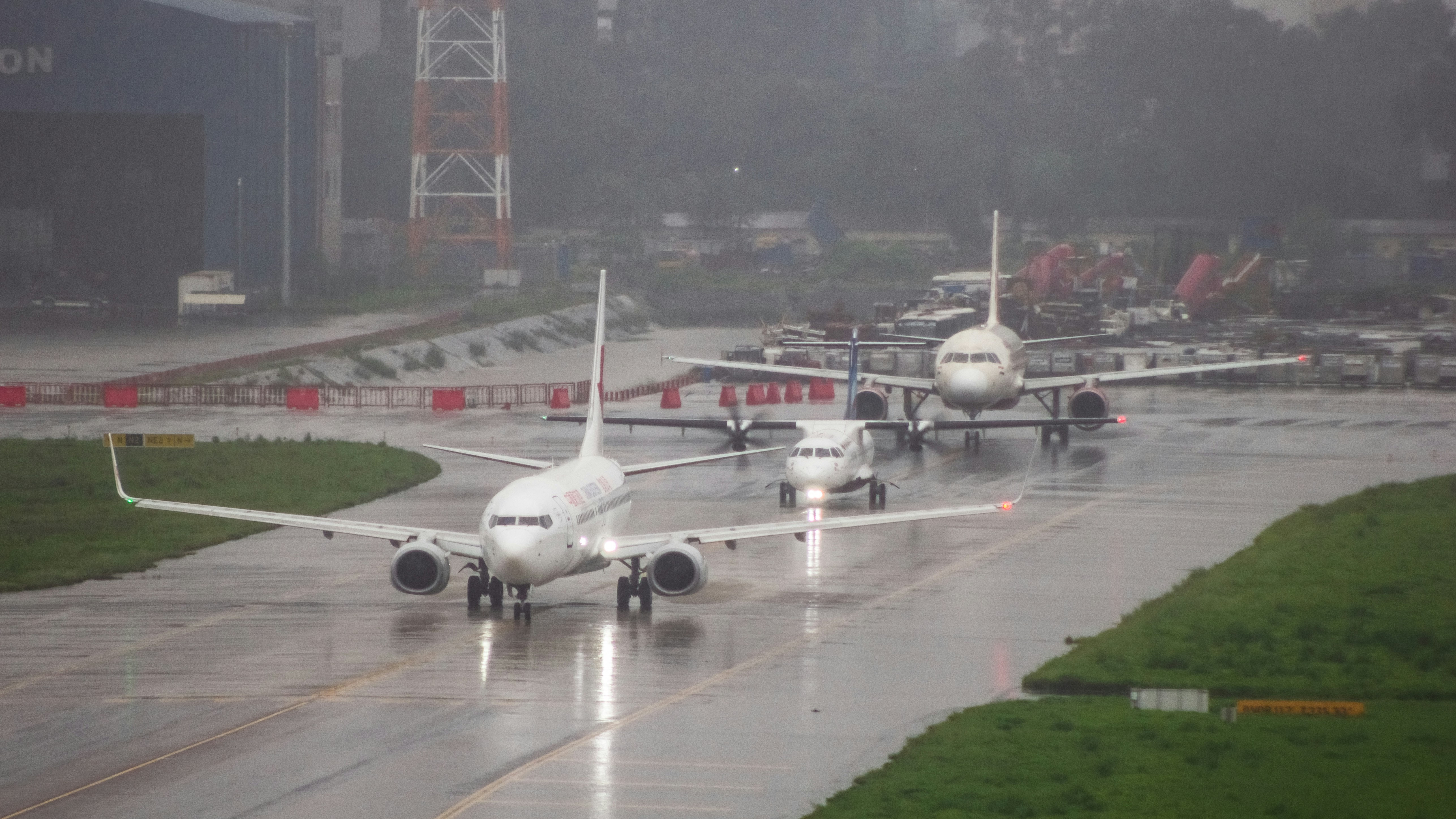A couple of airplanes that are on a runway, 
