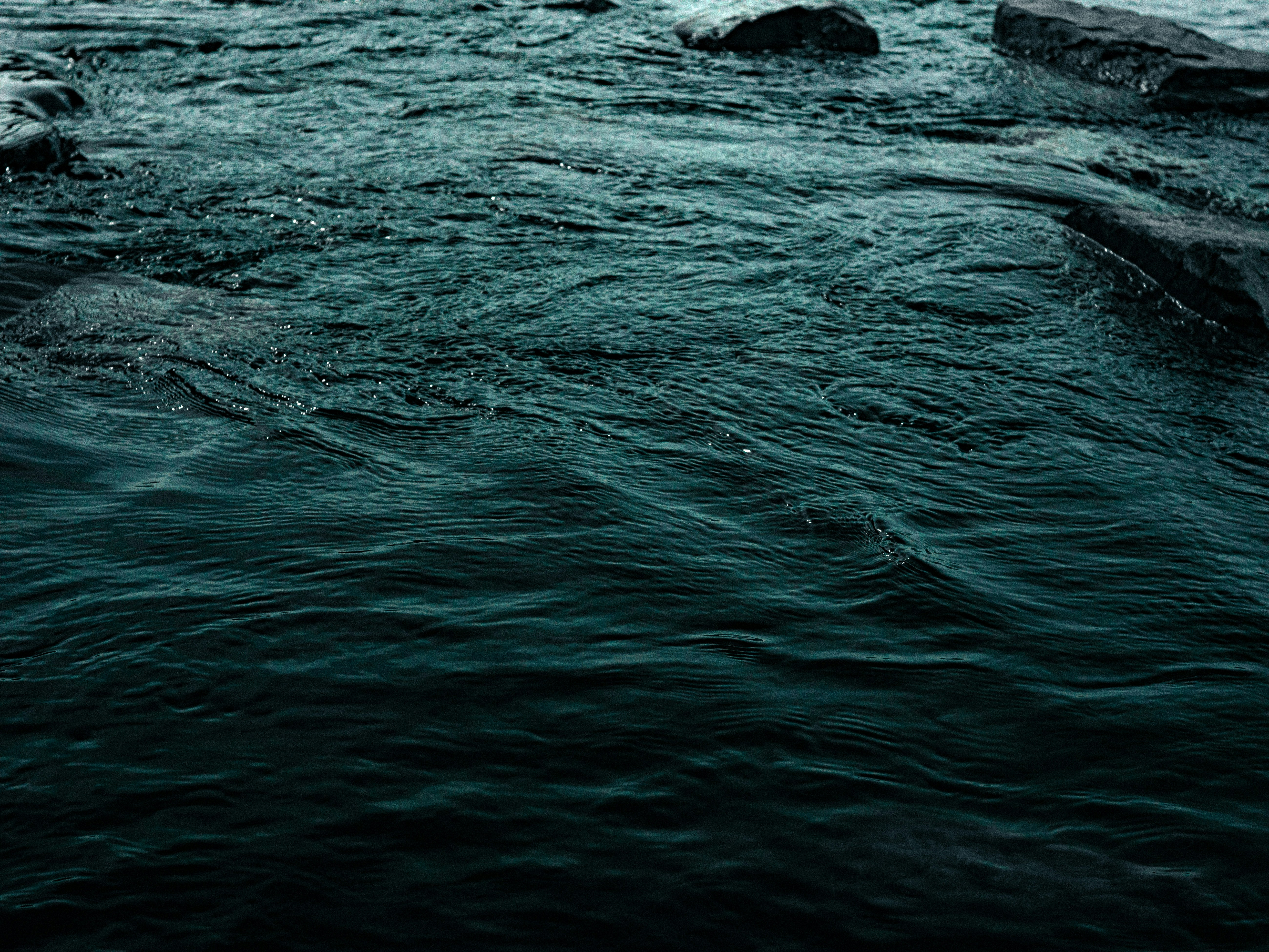 A man standing on a rock in the middle of a river