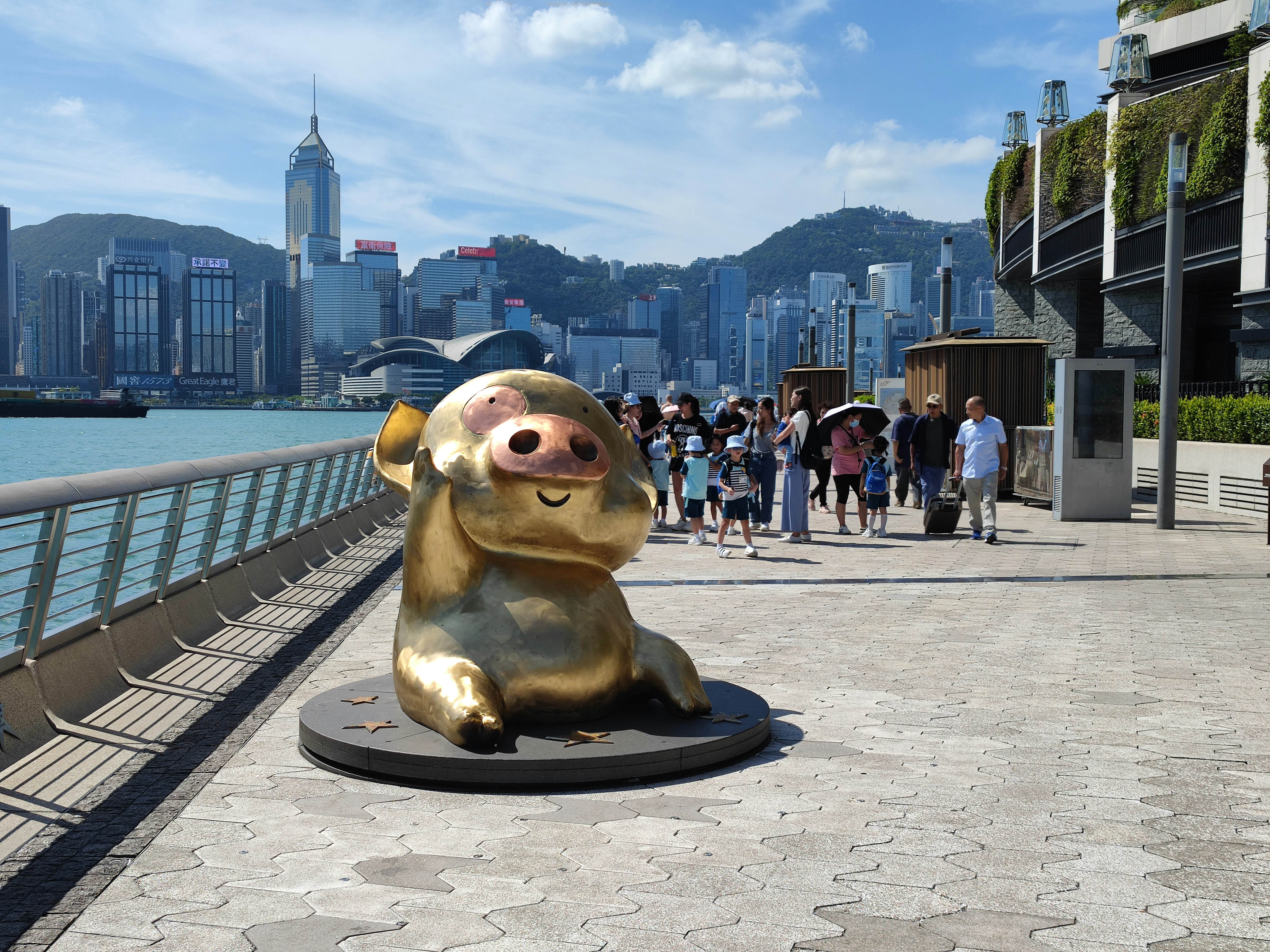 A statue of a slotty bear on a pier with a city in the background
