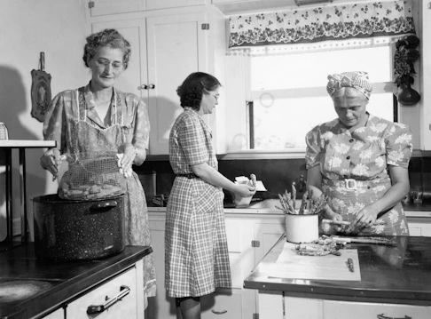 Three women working together in a vintage kitchen