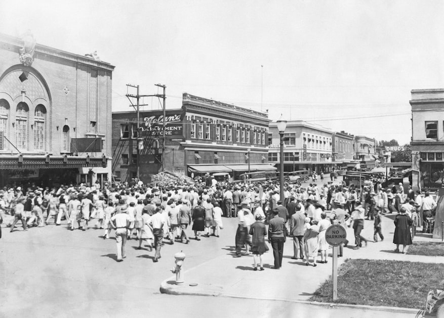 A crowd of people gathered on a street corner in conversation, representing the real customer discussions that live outside the indexable web