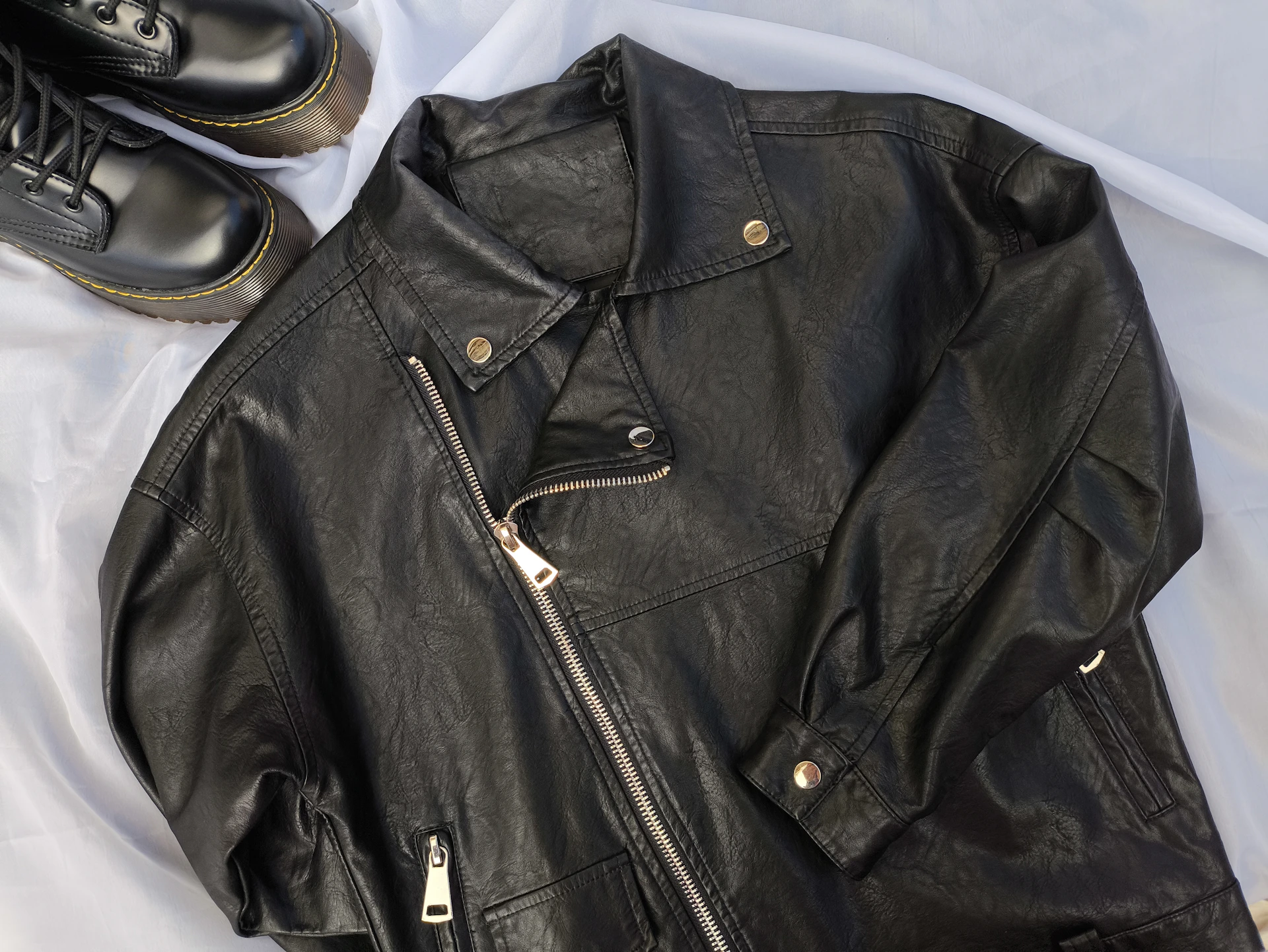 A pair of black shoes and a black leather jacket