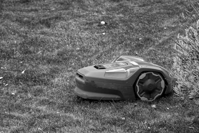 A black and white photo of a lawn mower laying on the ground