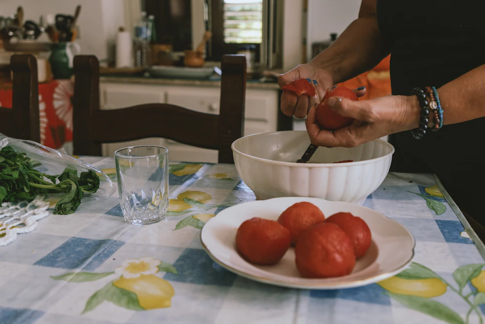 Tomaten worden gesneden aan een gedekte tafel