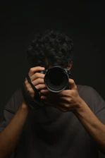 A man holding a camera up to his face