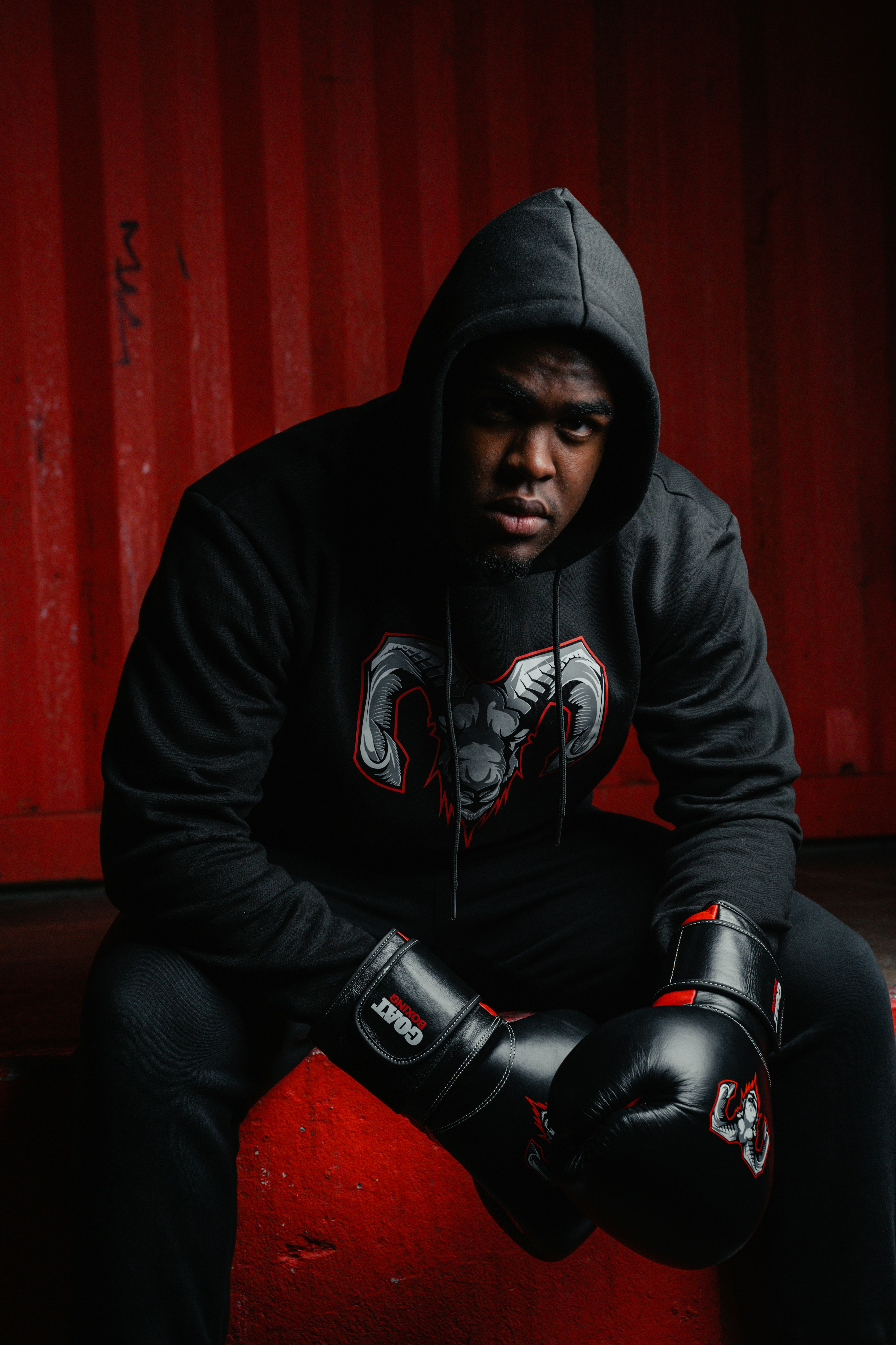 A man in a black hoodie and black gloves
