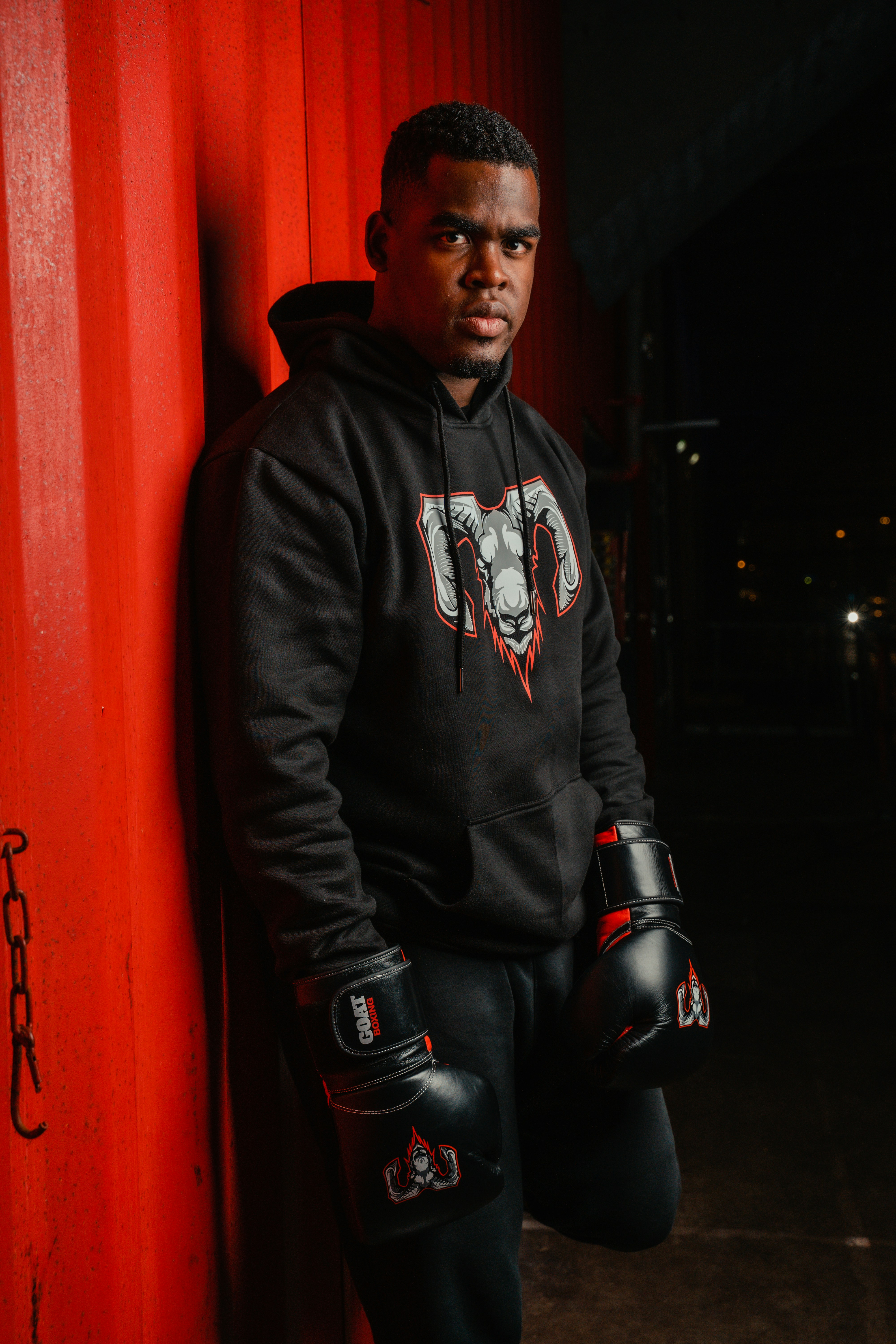 A man standing next to a red wall