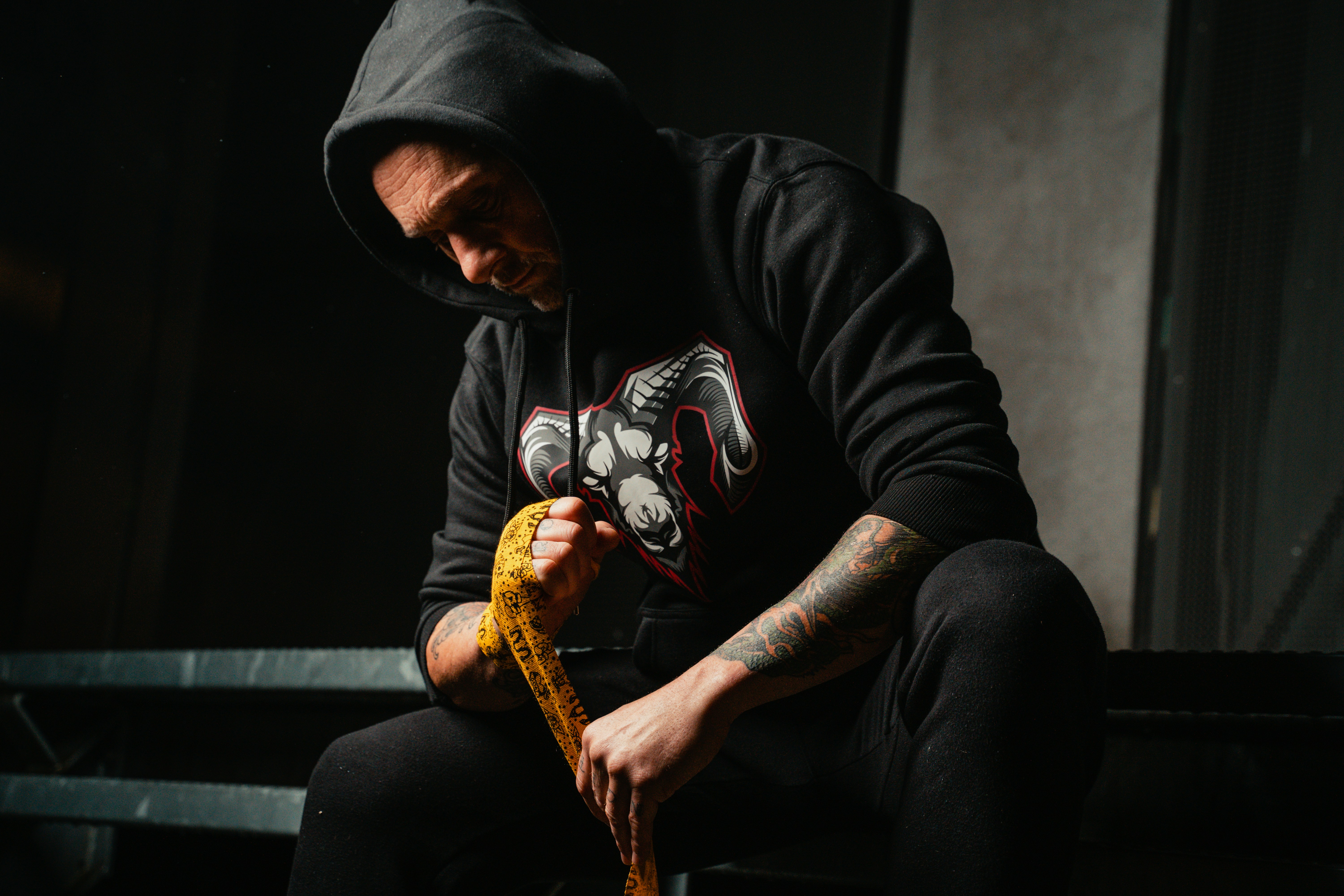 A man sitting on a bench with a snake in his hand