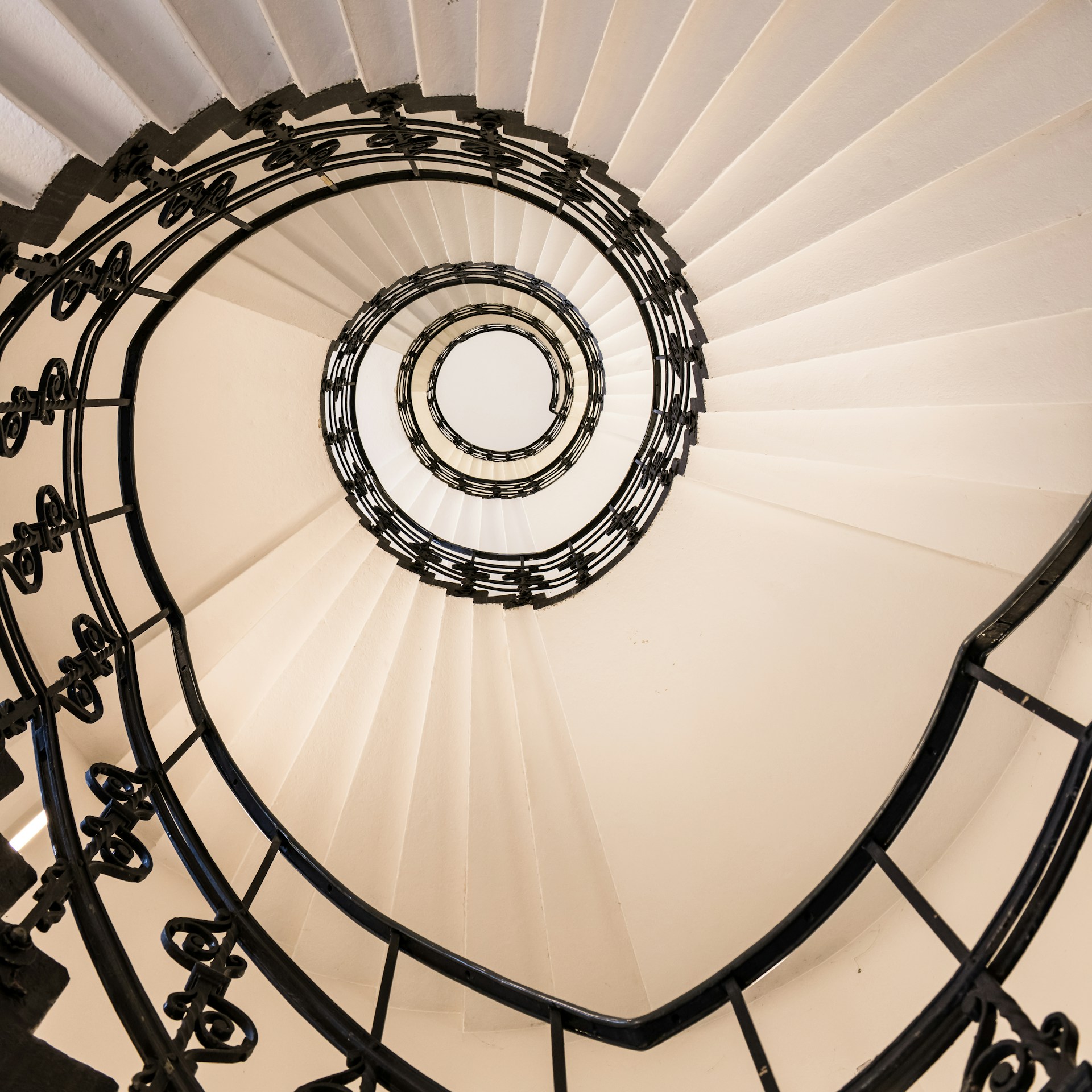 A spiral staircase in a building with white walls