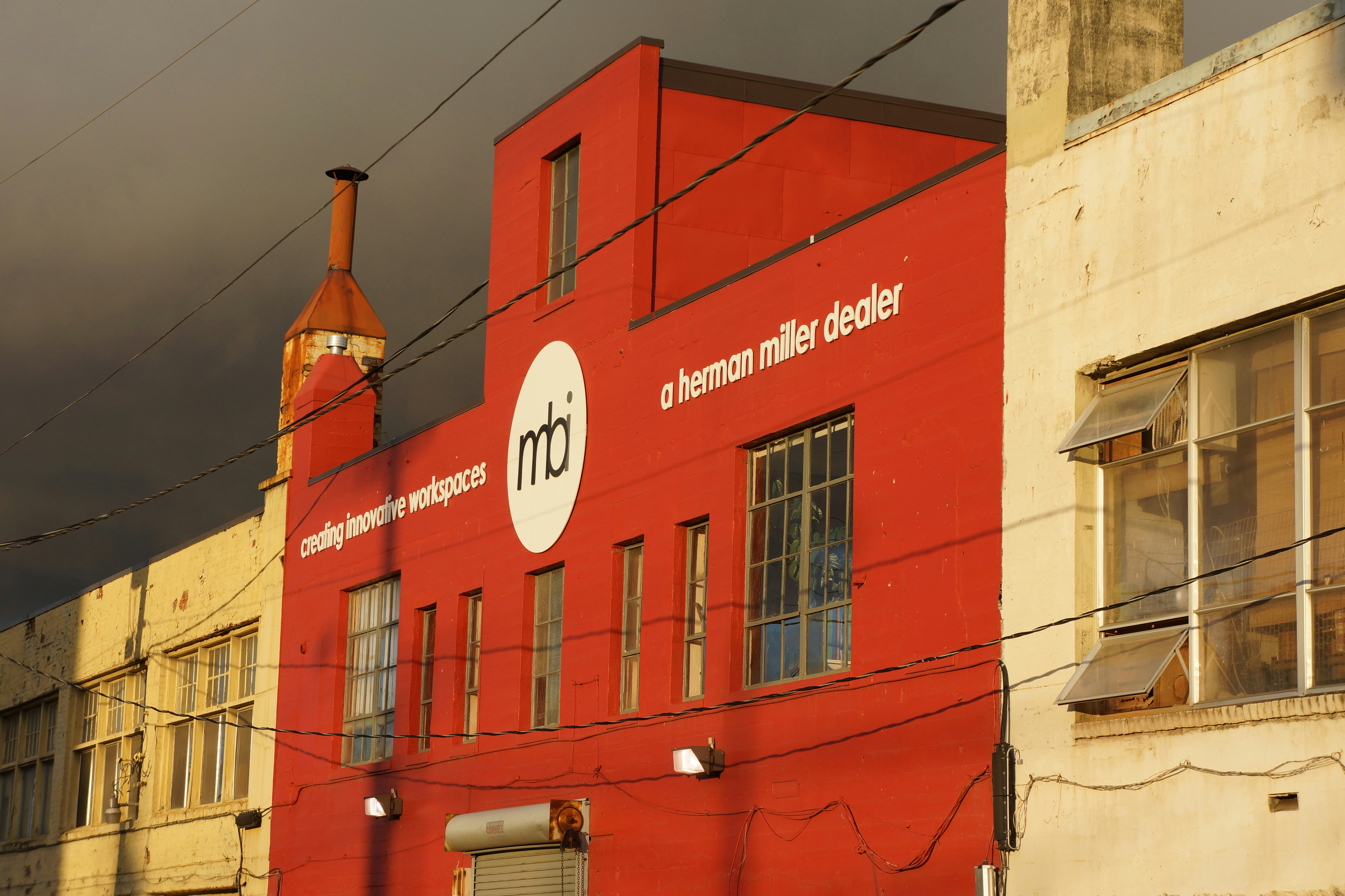 A red building sitting next to a tall white building