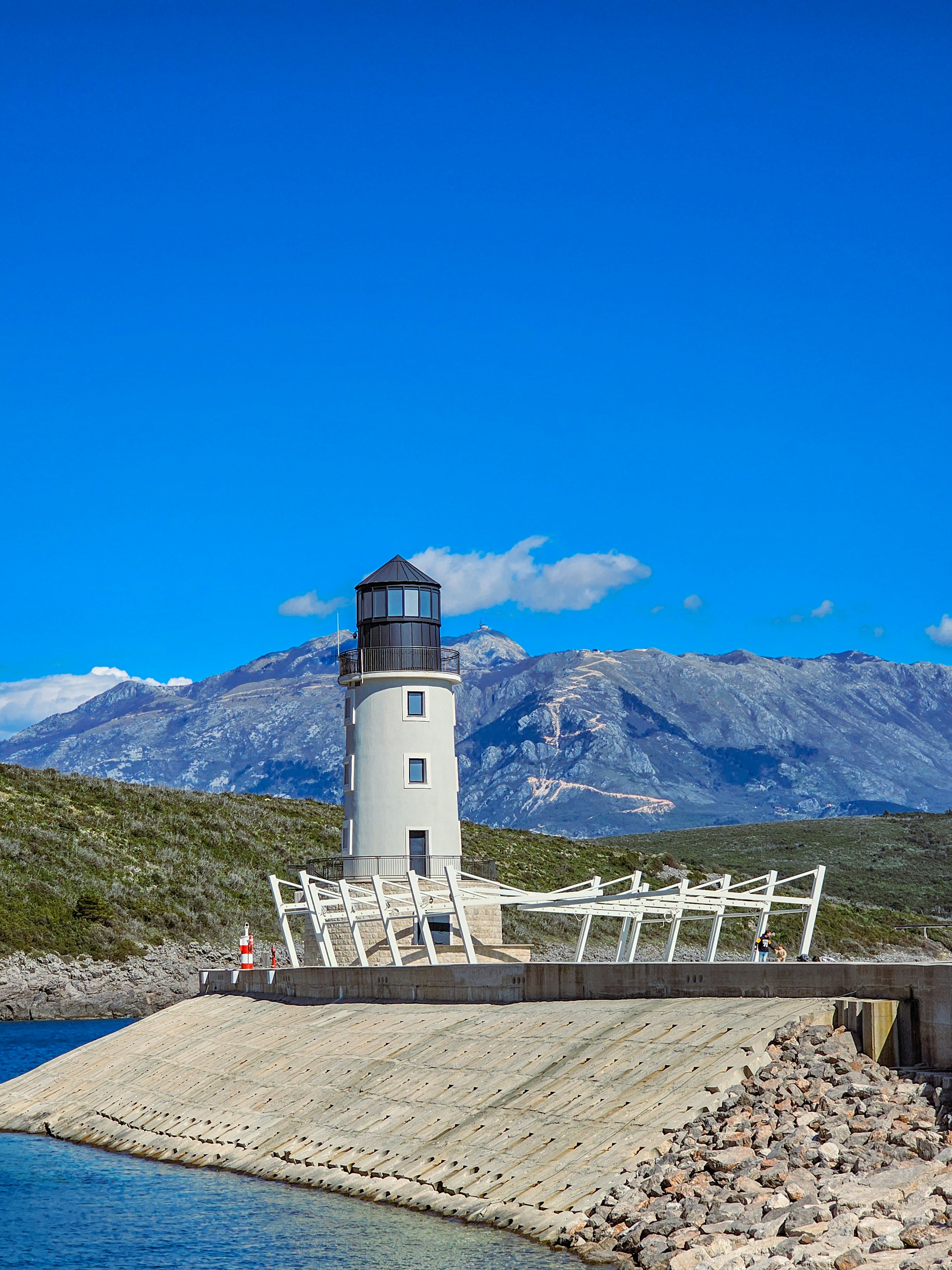 A light house sitting on top of a pier next to a body of water