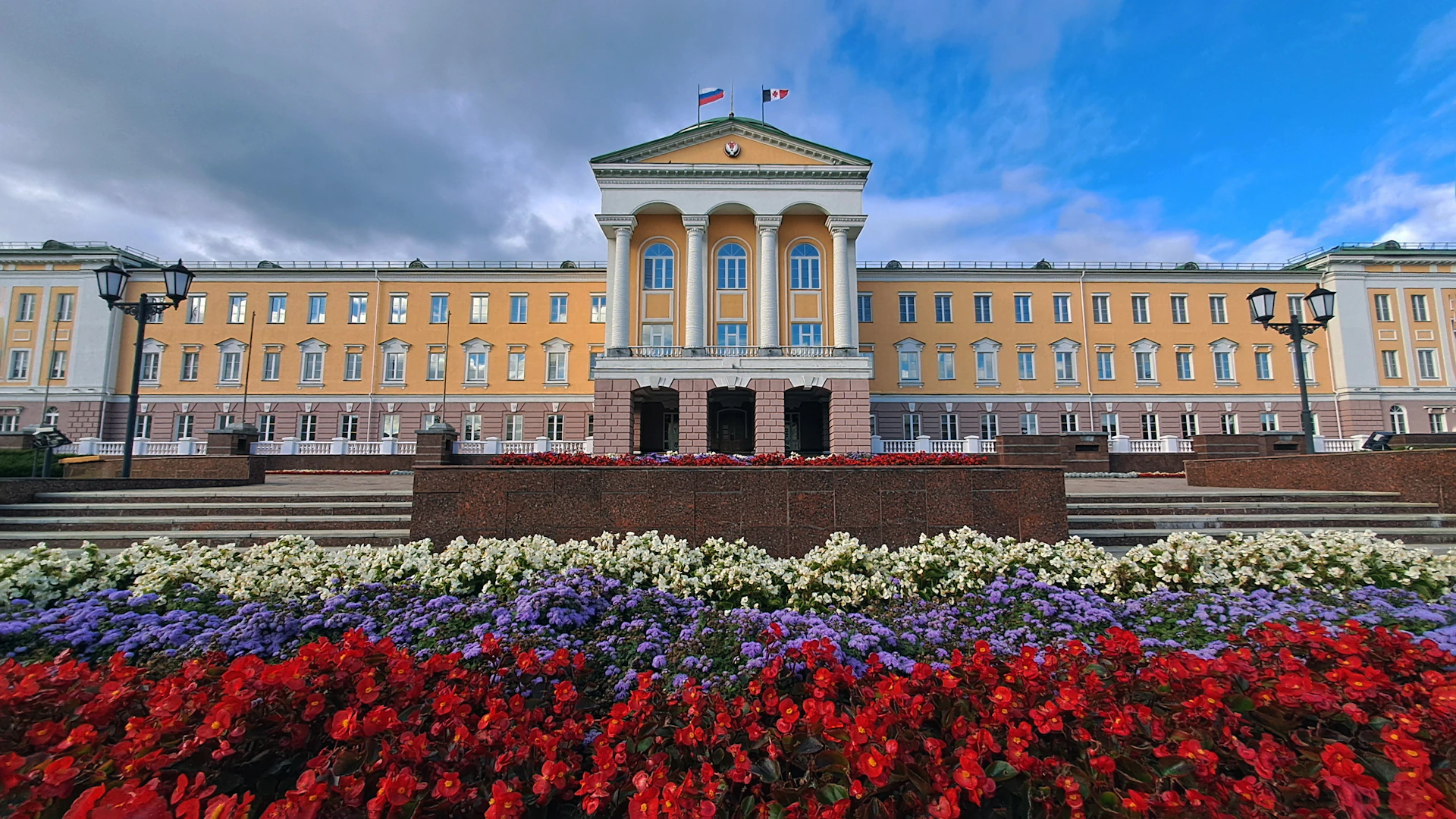 A large building with a lot of flowers in front of it