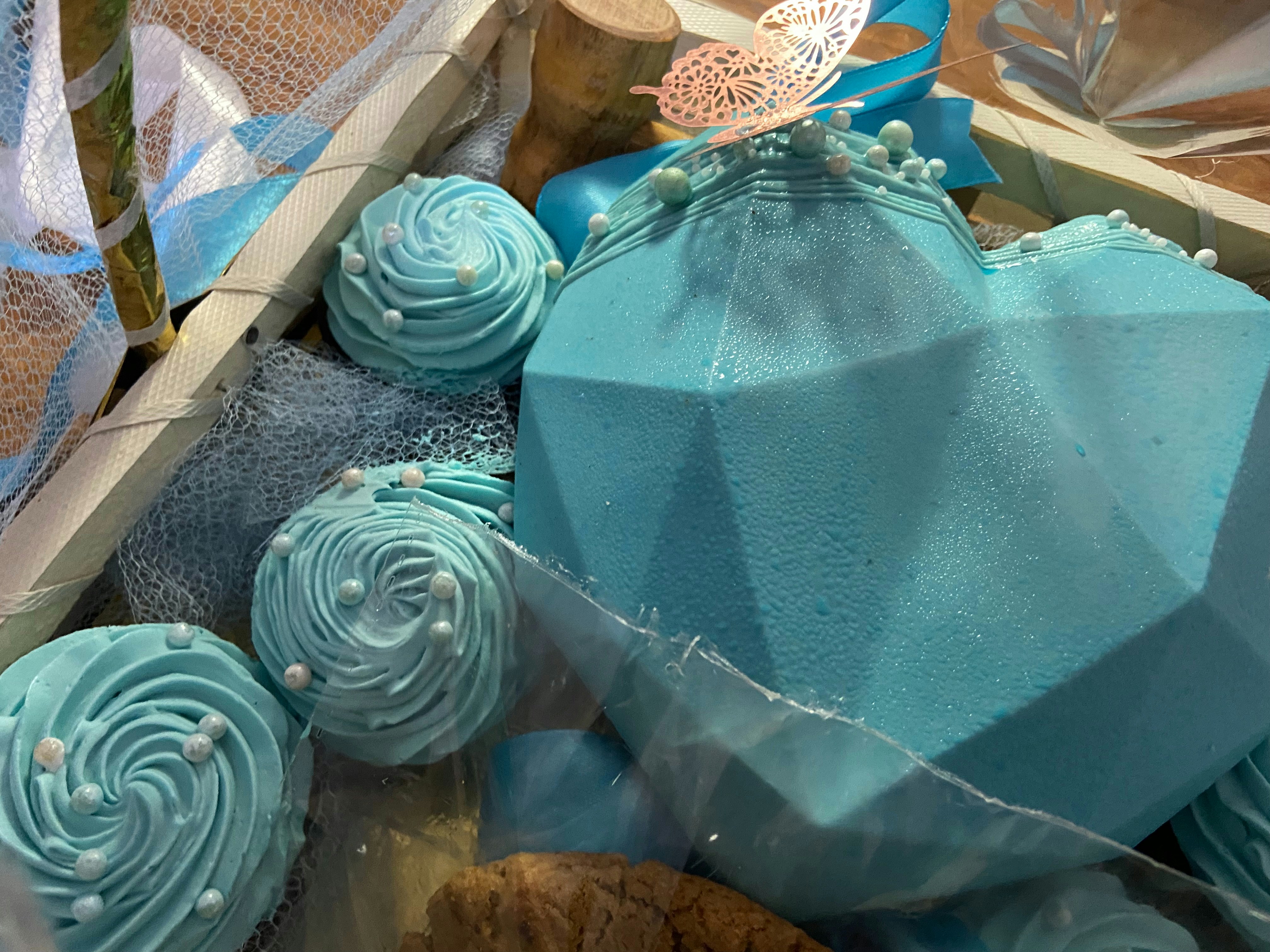 Premium holiday gift basket with assorted gourmet treats, chocolates, and festive decorations in wicker basket with red ribbon