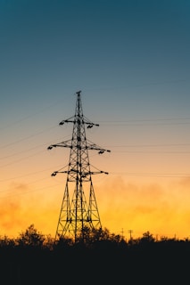 A tall tower sitting next to a forest under a cloudy sky
