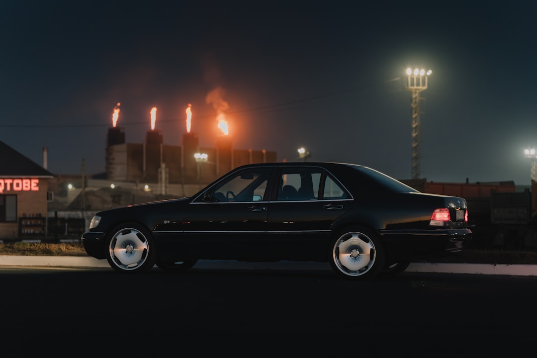 A black car parked in front of a building at night,