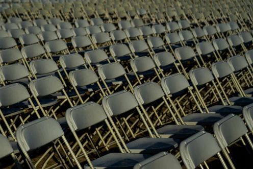 Rows of empty chairs sitting in a field