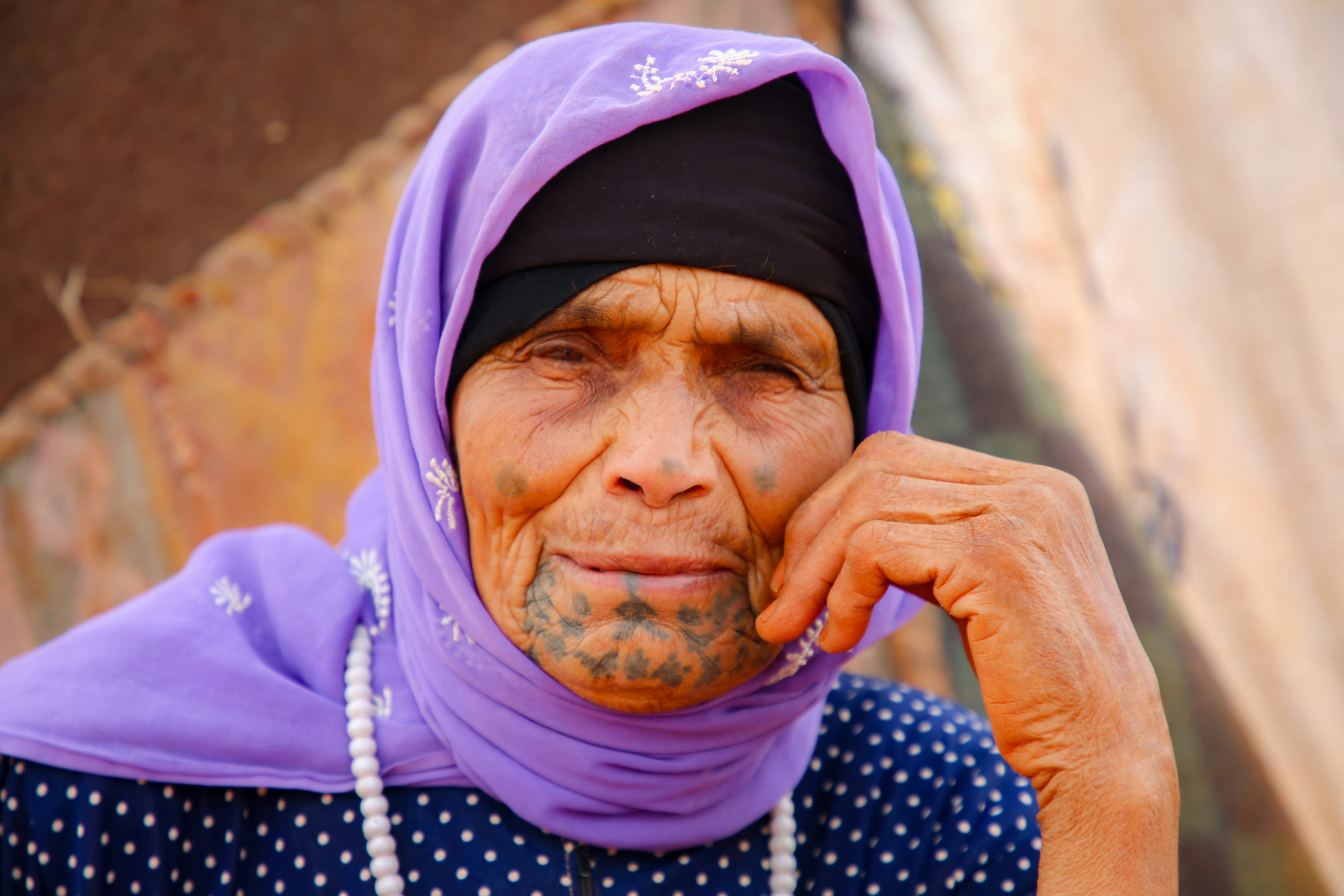 A woman in a purple headscarf talking on a cell phone