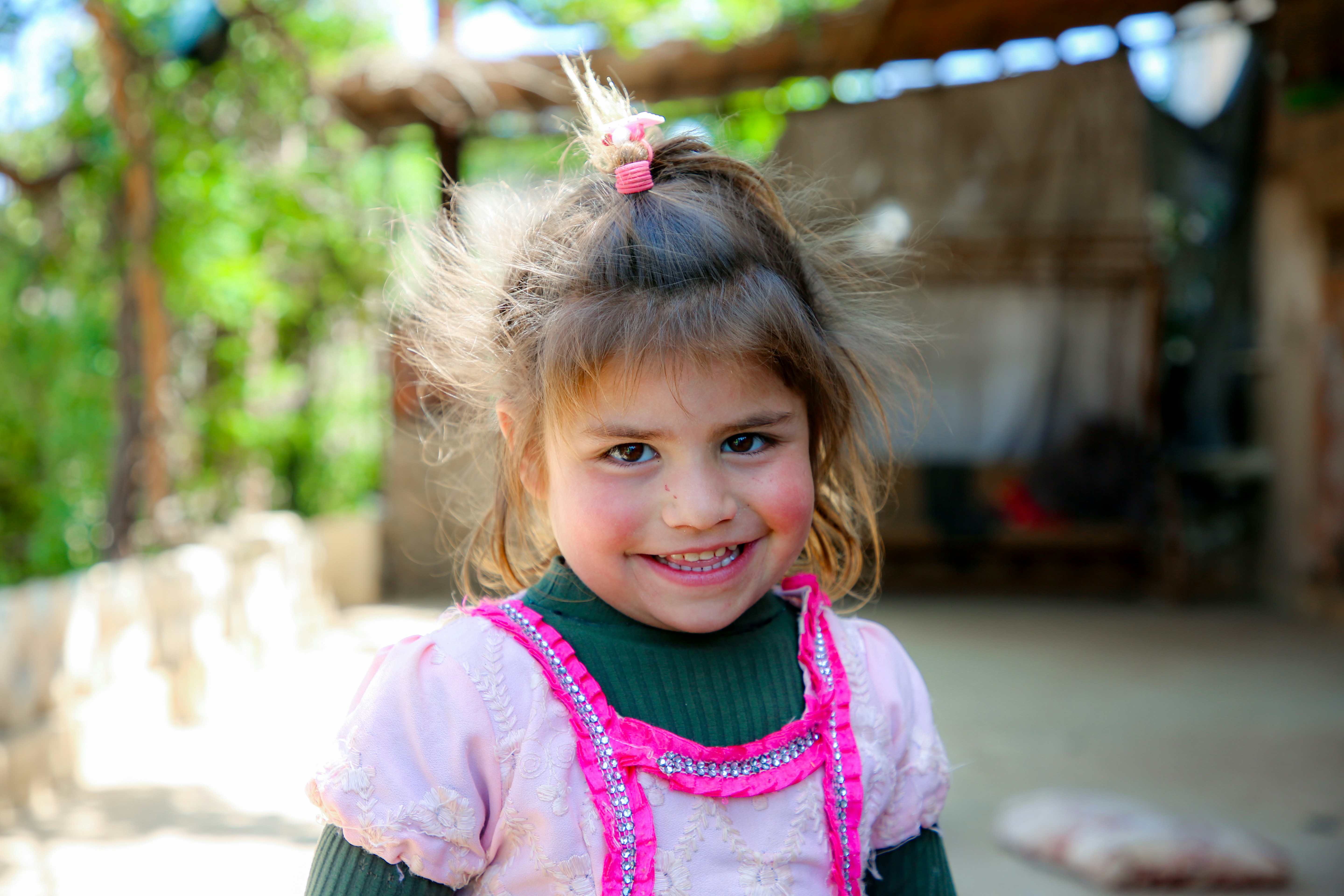 A little girl in a green and pink dress