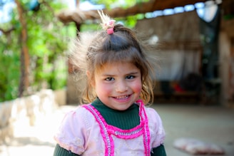 A little girl in a green and pink dress