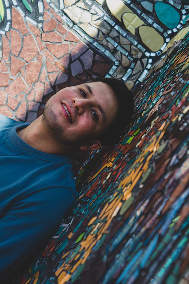 A man laying on the ground in front of a stained glass wall