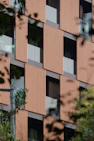 A tall building with lots of windows next to trees