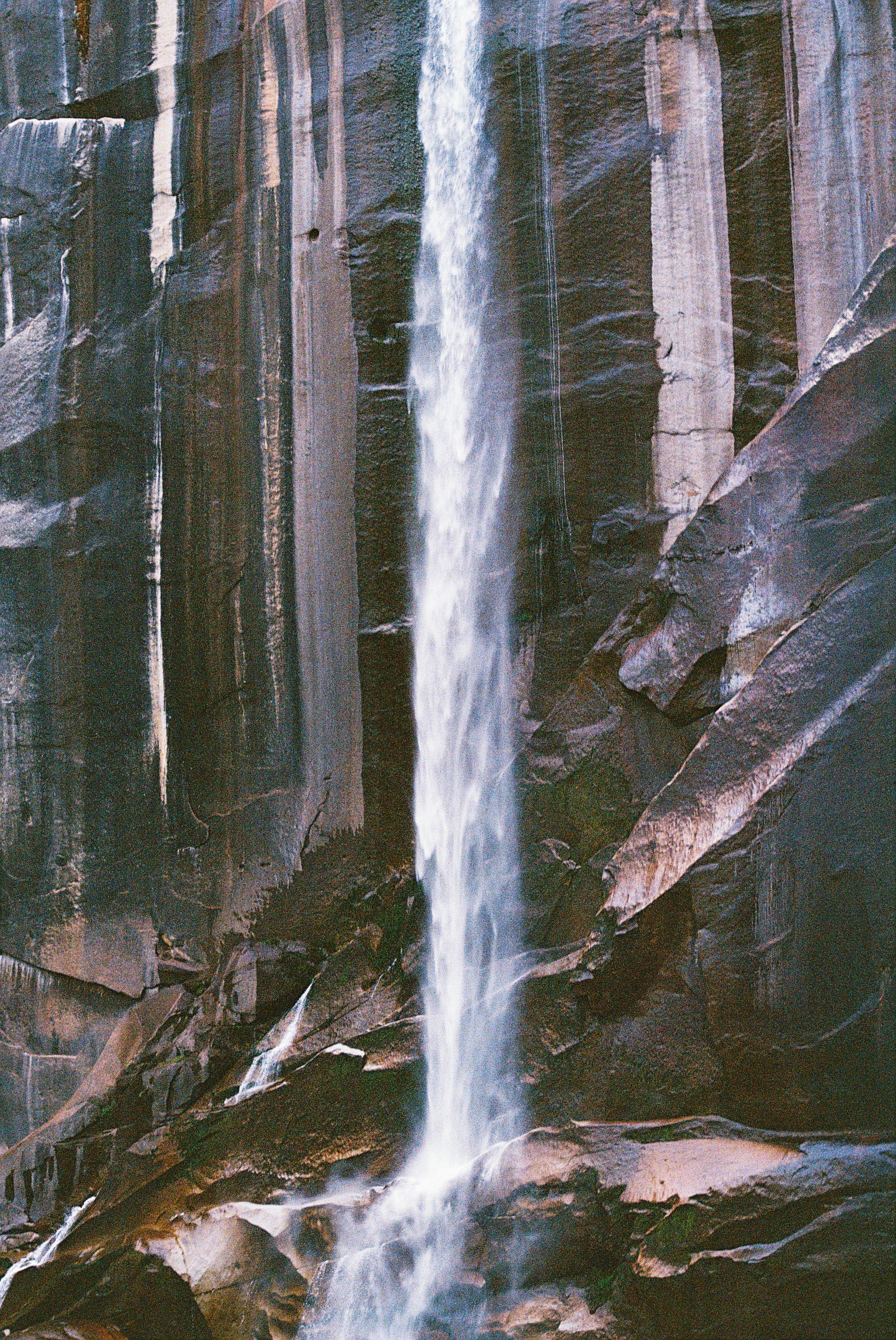 Un hombre de pie frente a una cascada