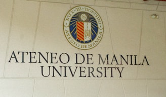 A sign on the side of a building that says atenco de manila university