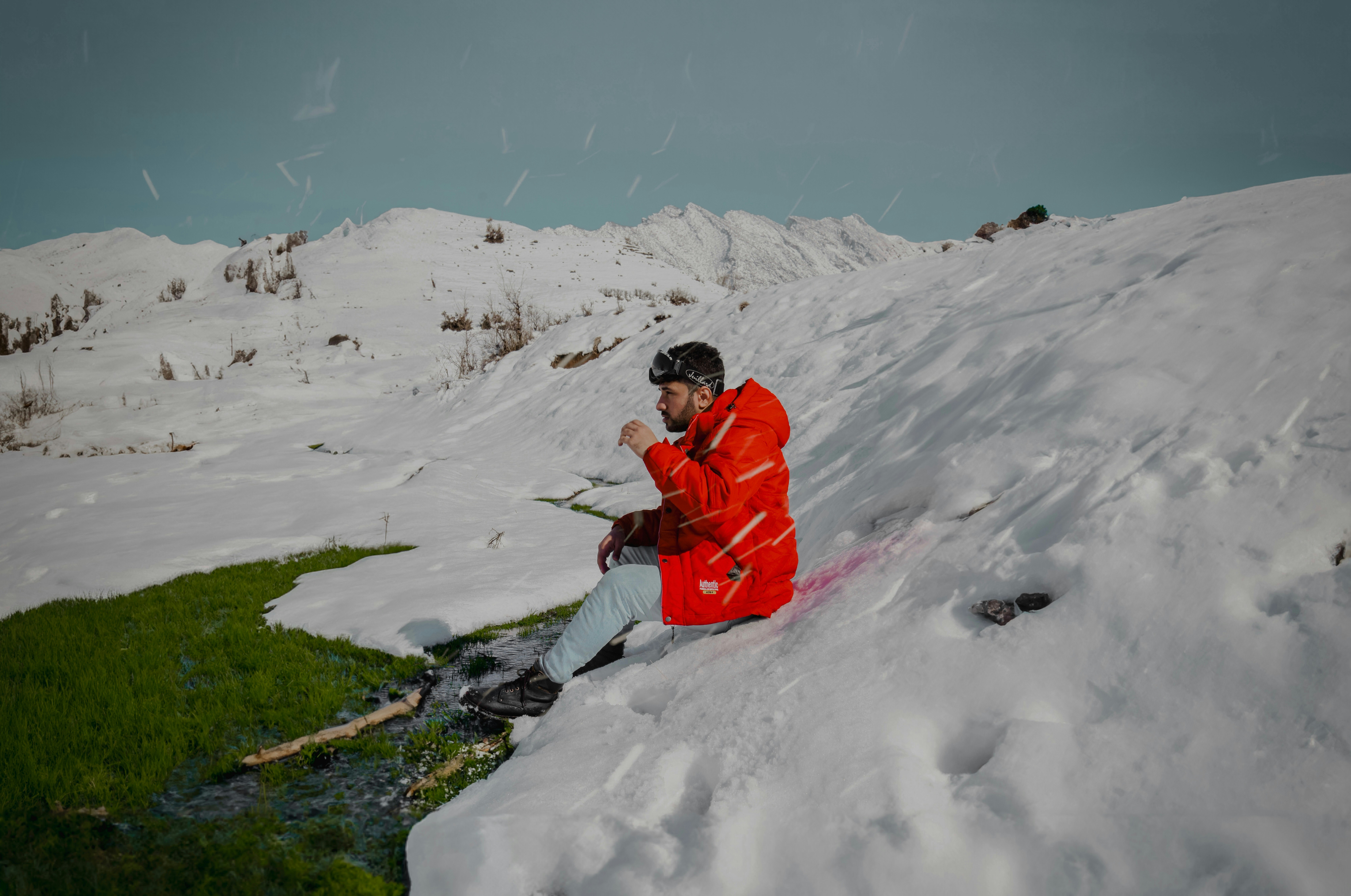 A man sitting on top of a snow covered slope