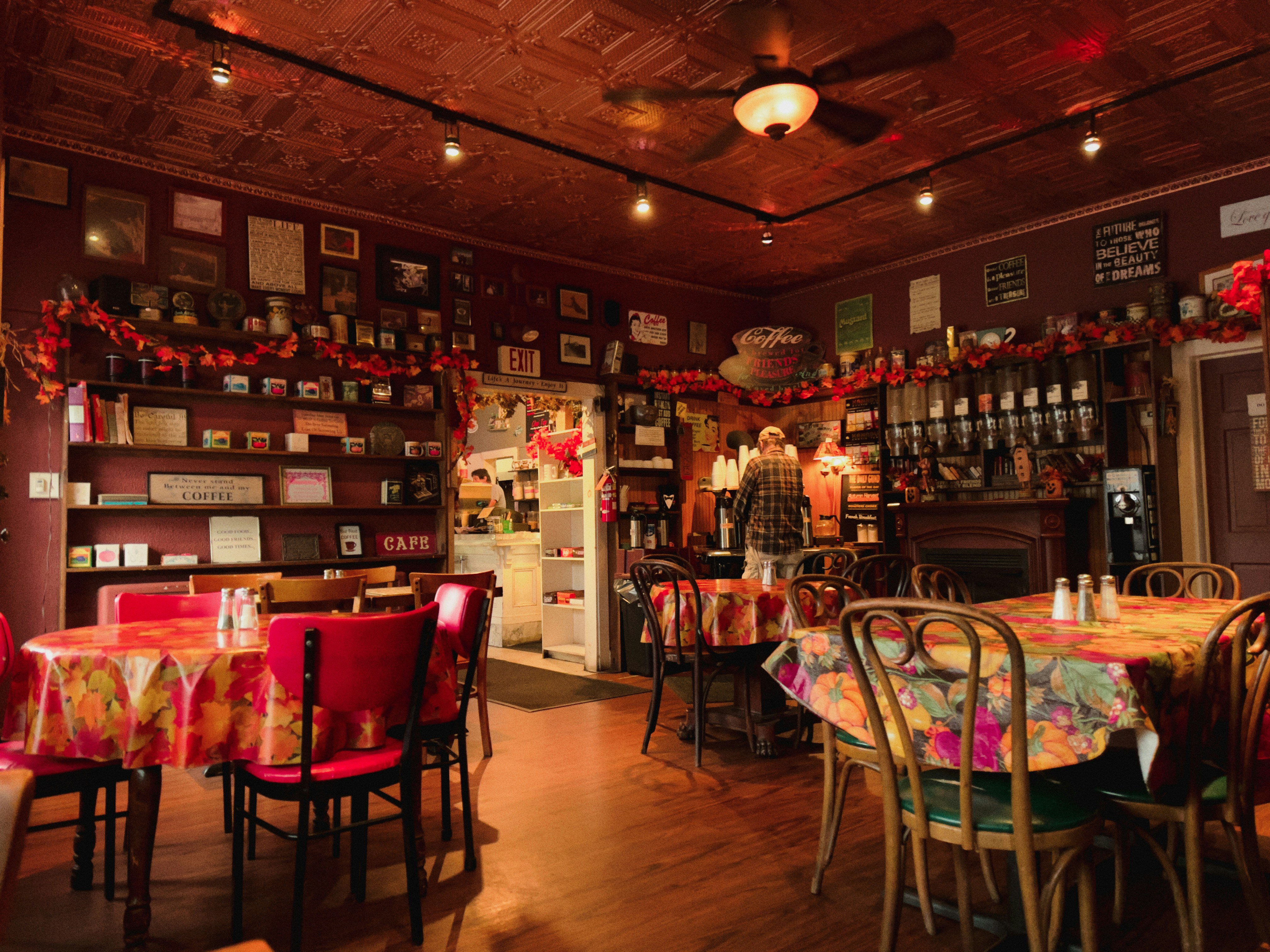 A restaurant with tables, chairs, and pictures on the wall