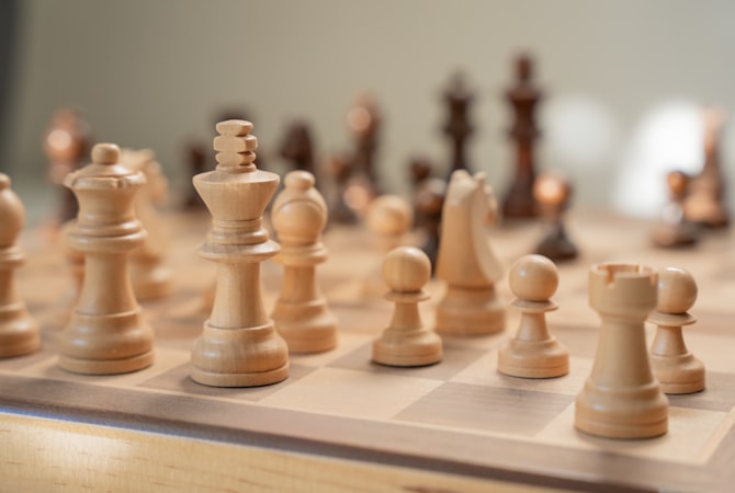 Close-up overhead view of a chess board mid-game with pieces casting shadows