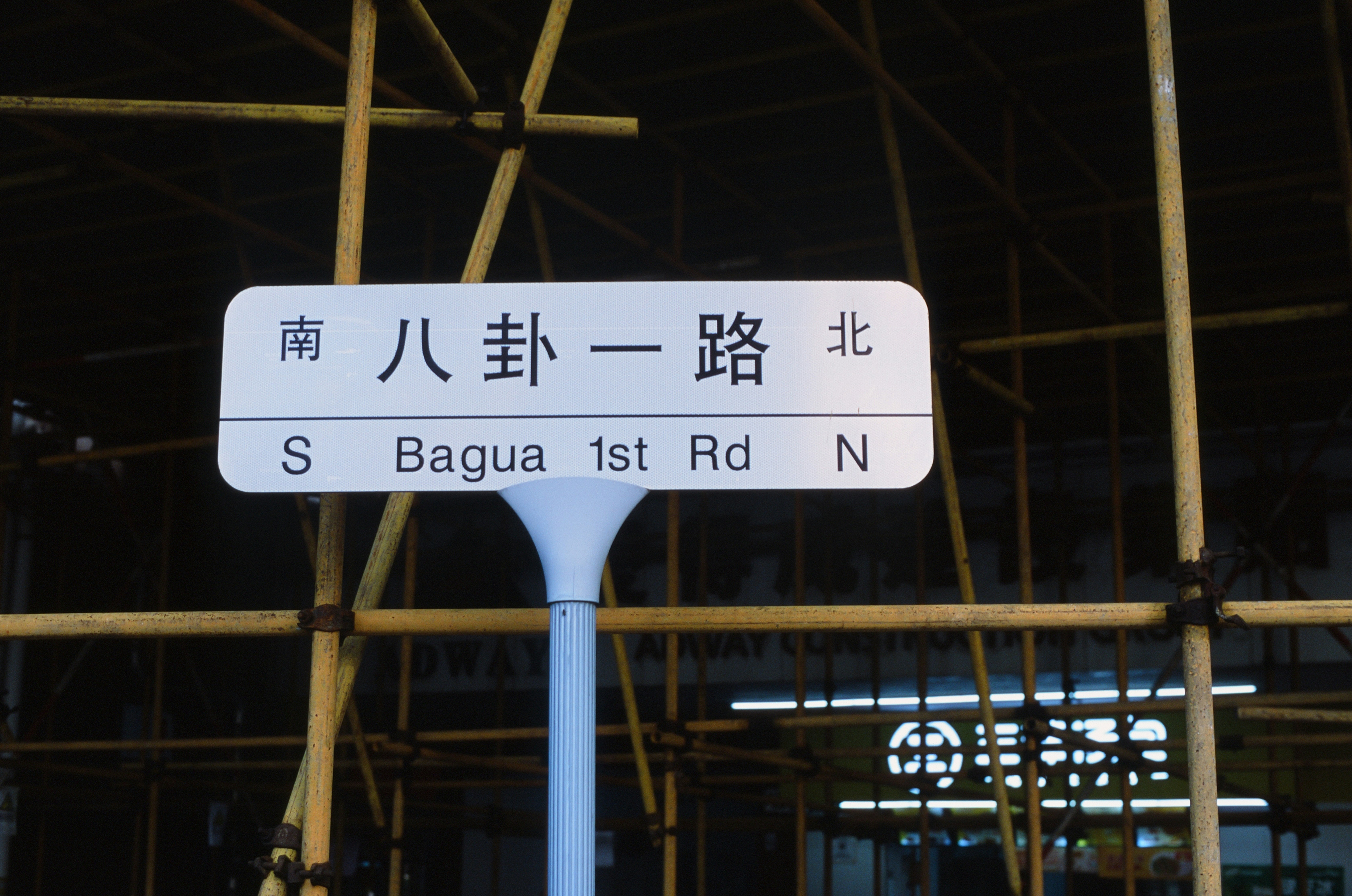 A street sign in front of a building under construction