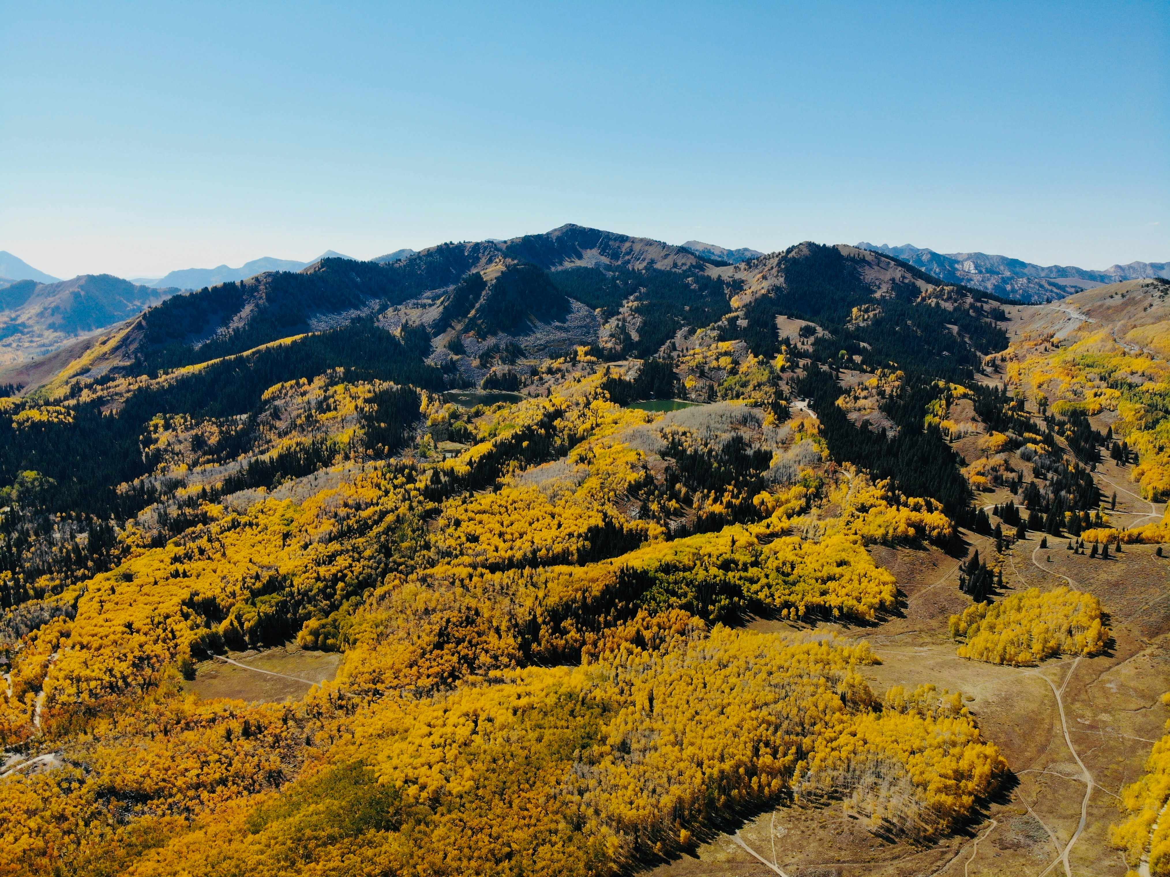 Dramatic aerial view of Lake Tahoe with snow-capped Sierra Nevada mountains in autumn with golden aspen trees