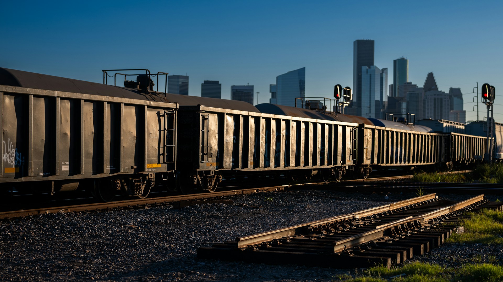 A train traveling through a city next to tall buildings