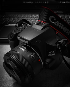 A camera sitting on top of a table next to a laptop