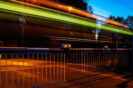 A train passing by a fence at night