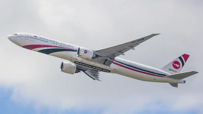 A large jetliner flying through a cloudy blue sky