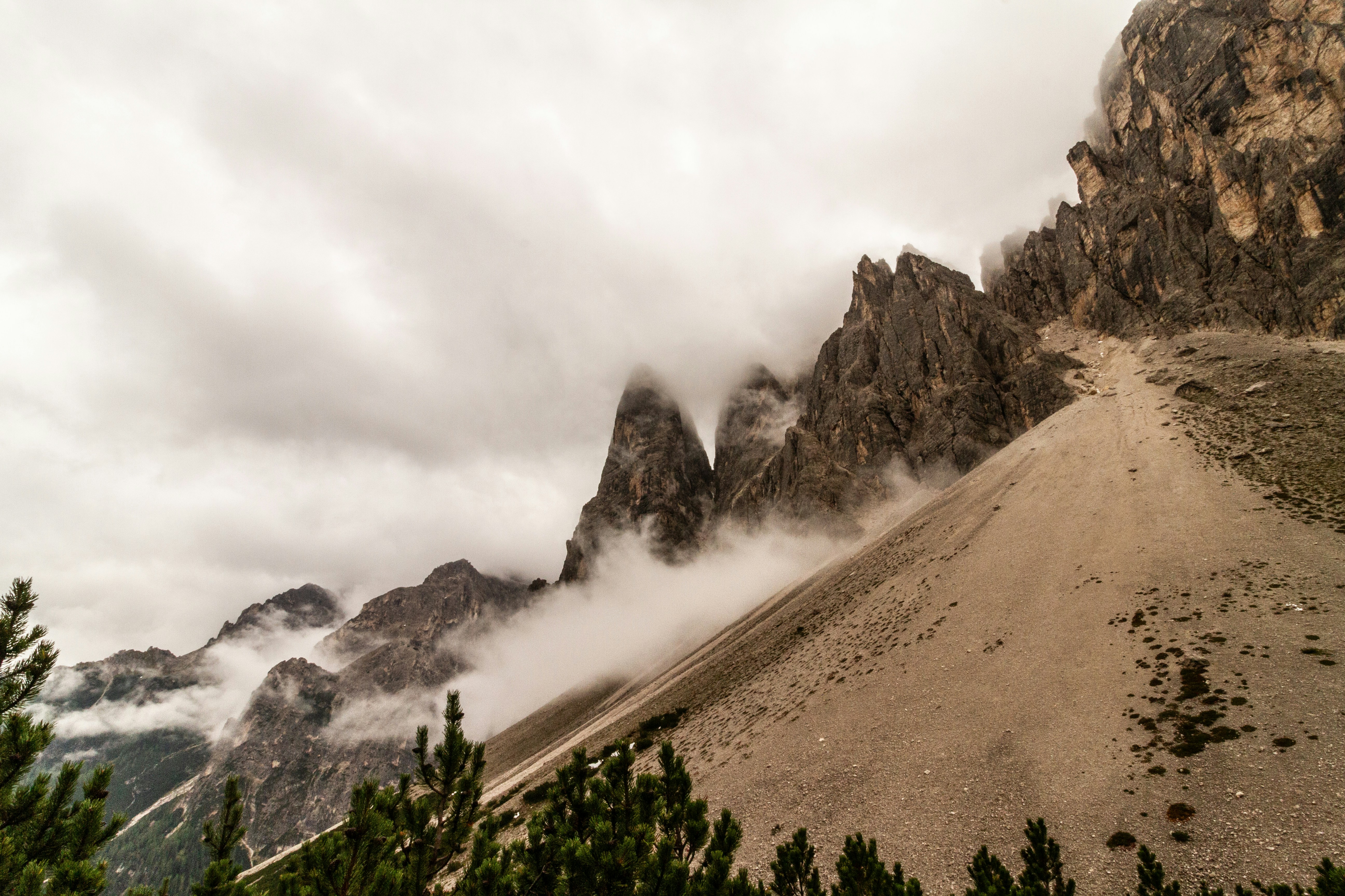 A mountain covered in mist and clouds on a cloudy day