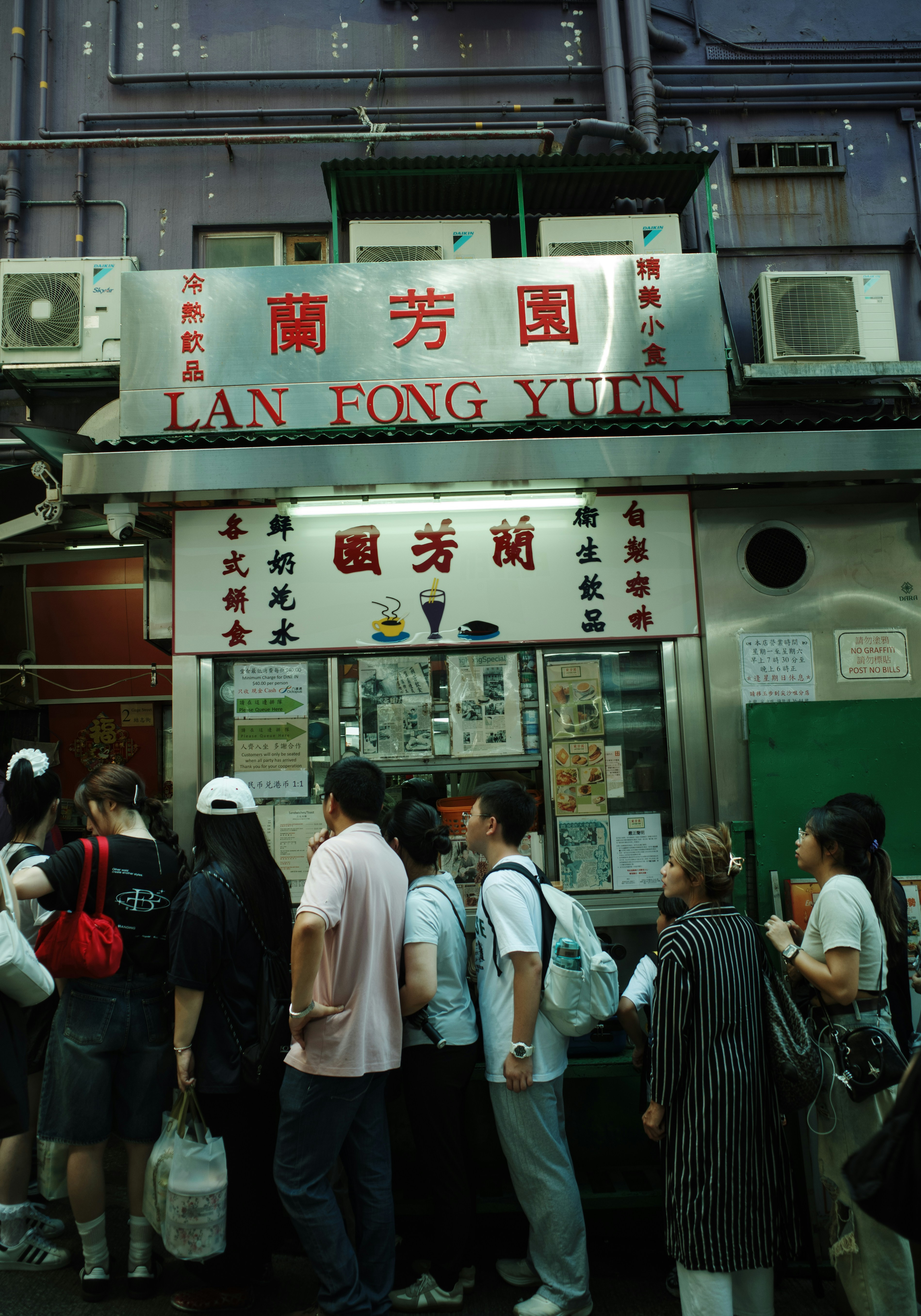 A group of people standing outside of a restaurant