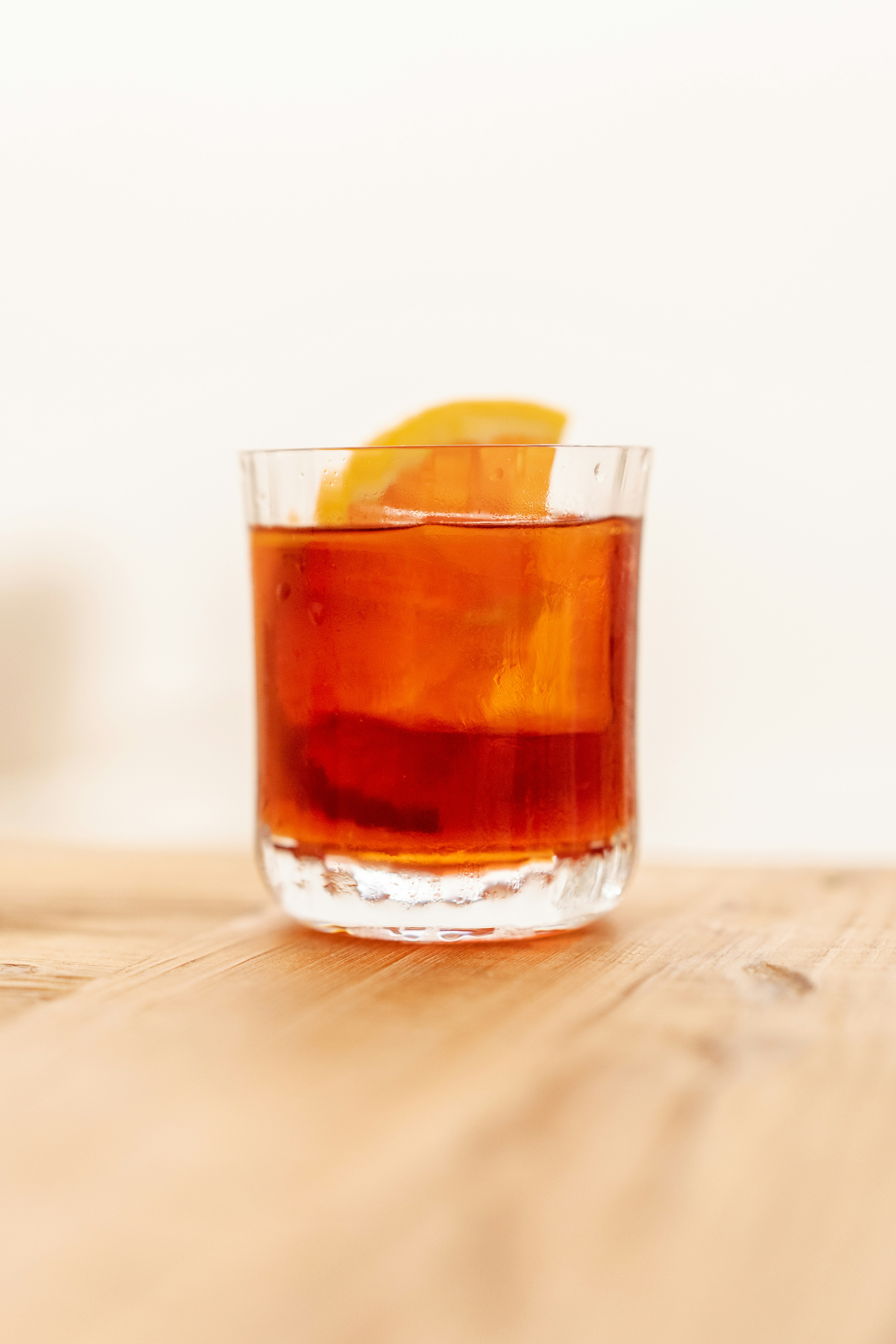 A glass filled with a drink sitting on top of a wooden table