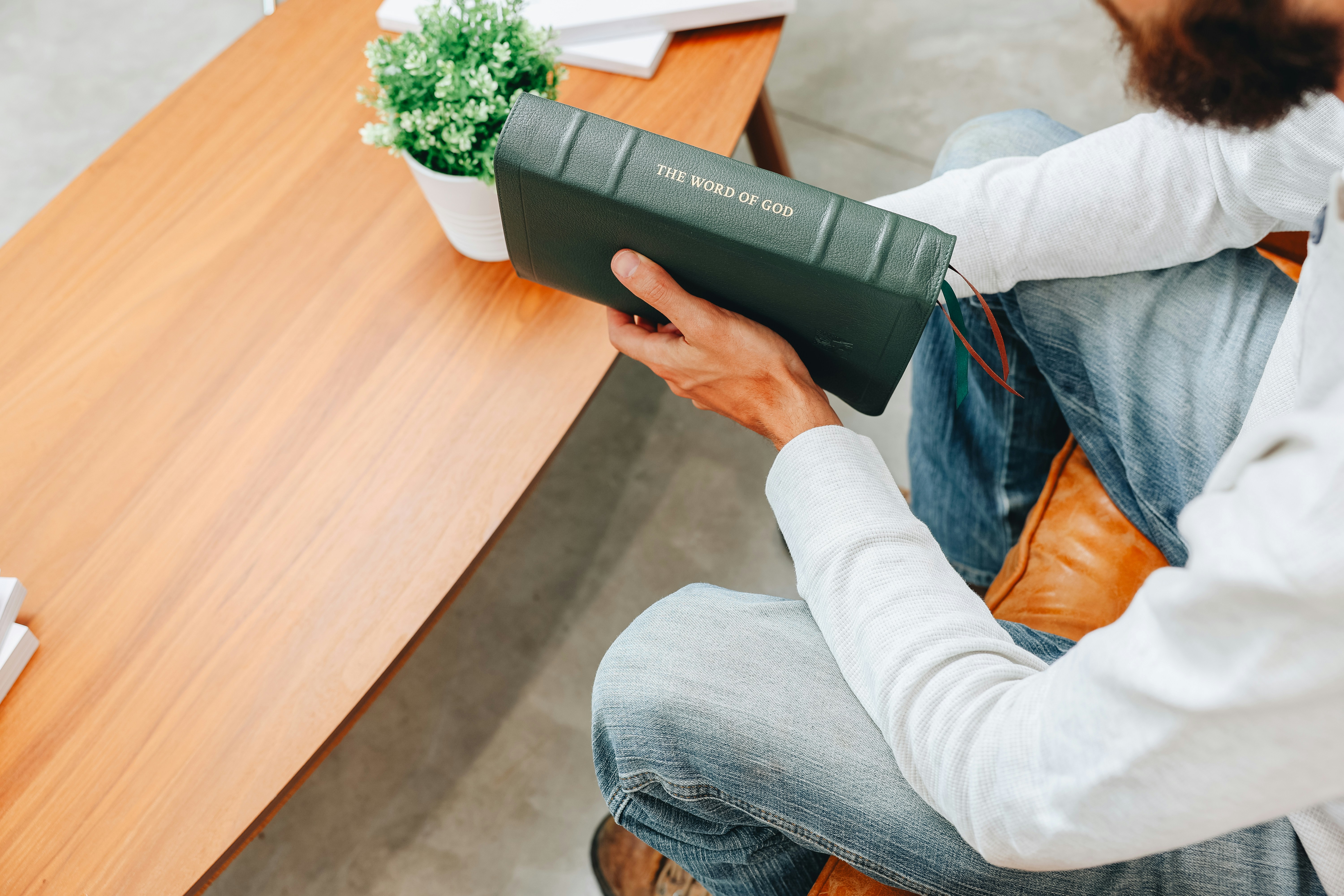 Ein Mann sitzt an einem Tisch und liest ein Buch