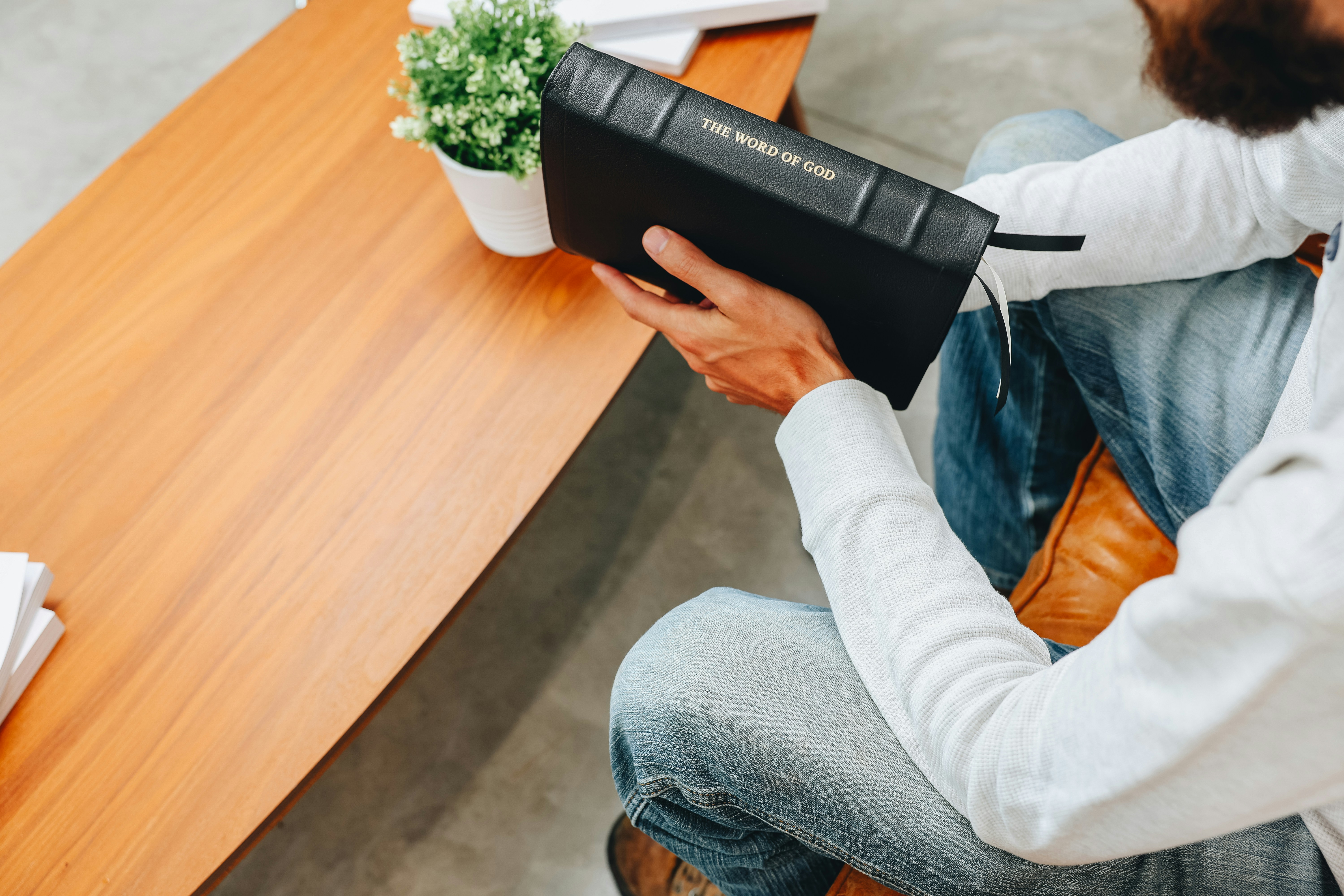 Ein Mann sitzt mit einem Buch an einem Tisch