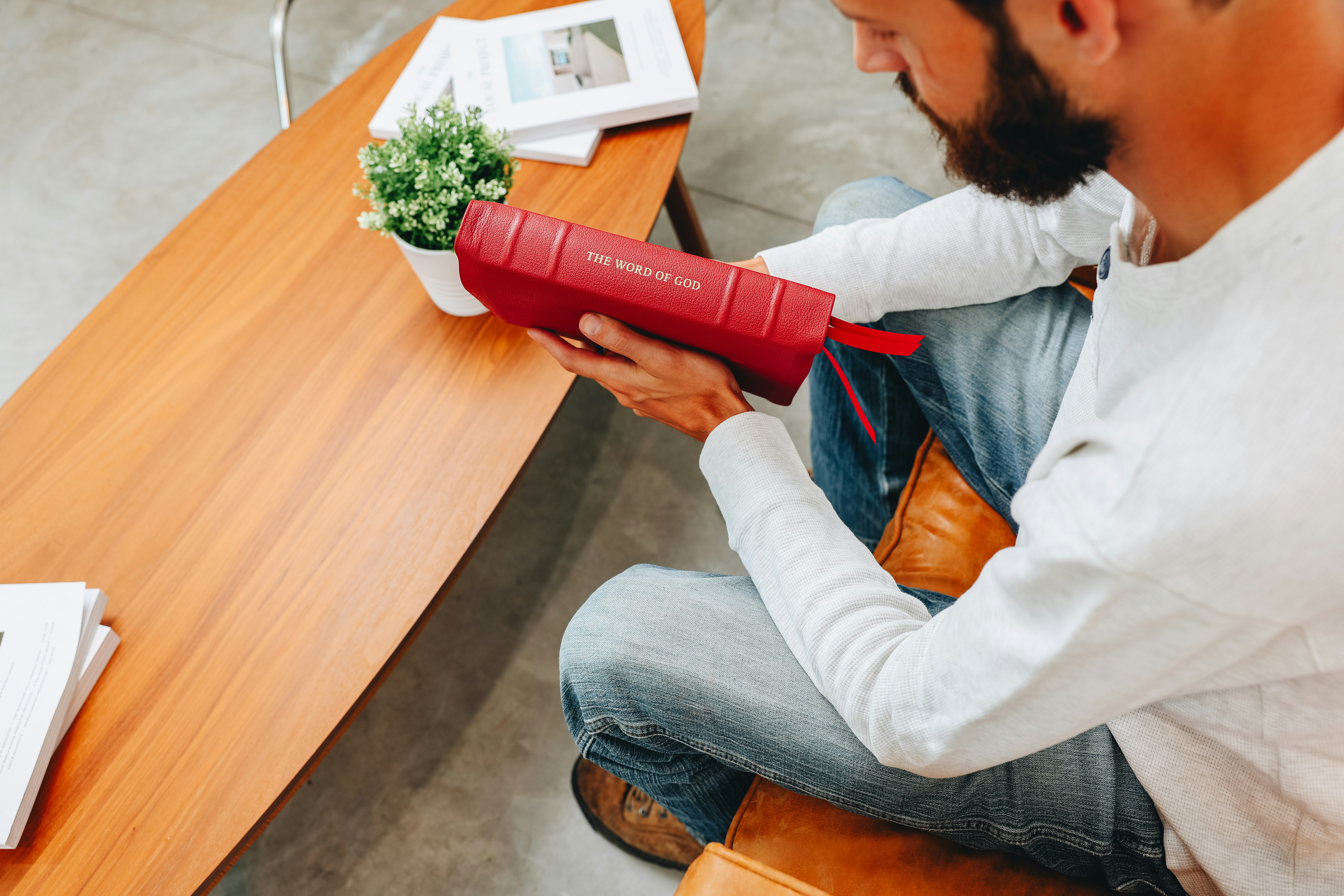 Ein Mann sitzt an einem Tisch mit einem Fön in der Hand