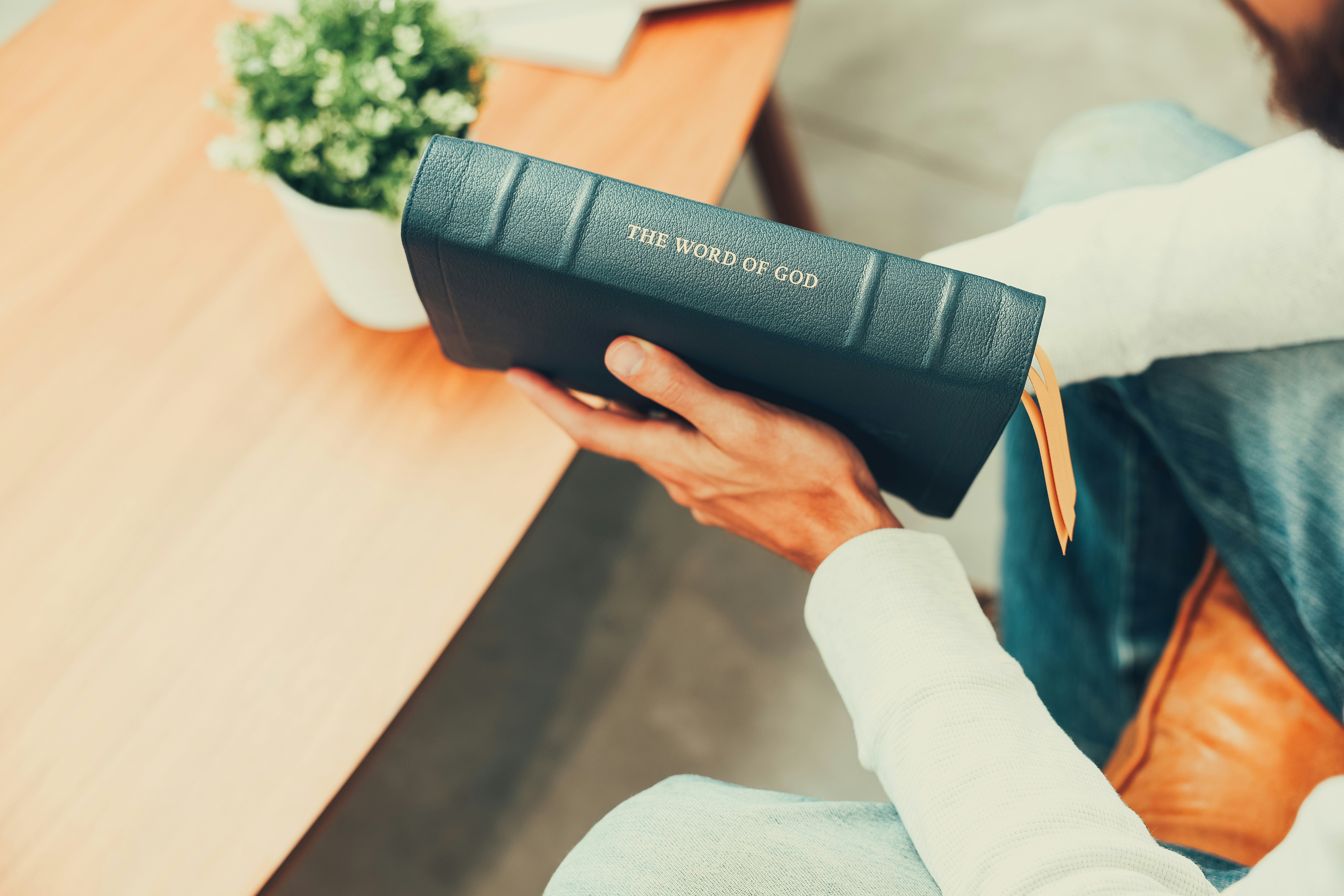 A man sitting at a table holding a remote control