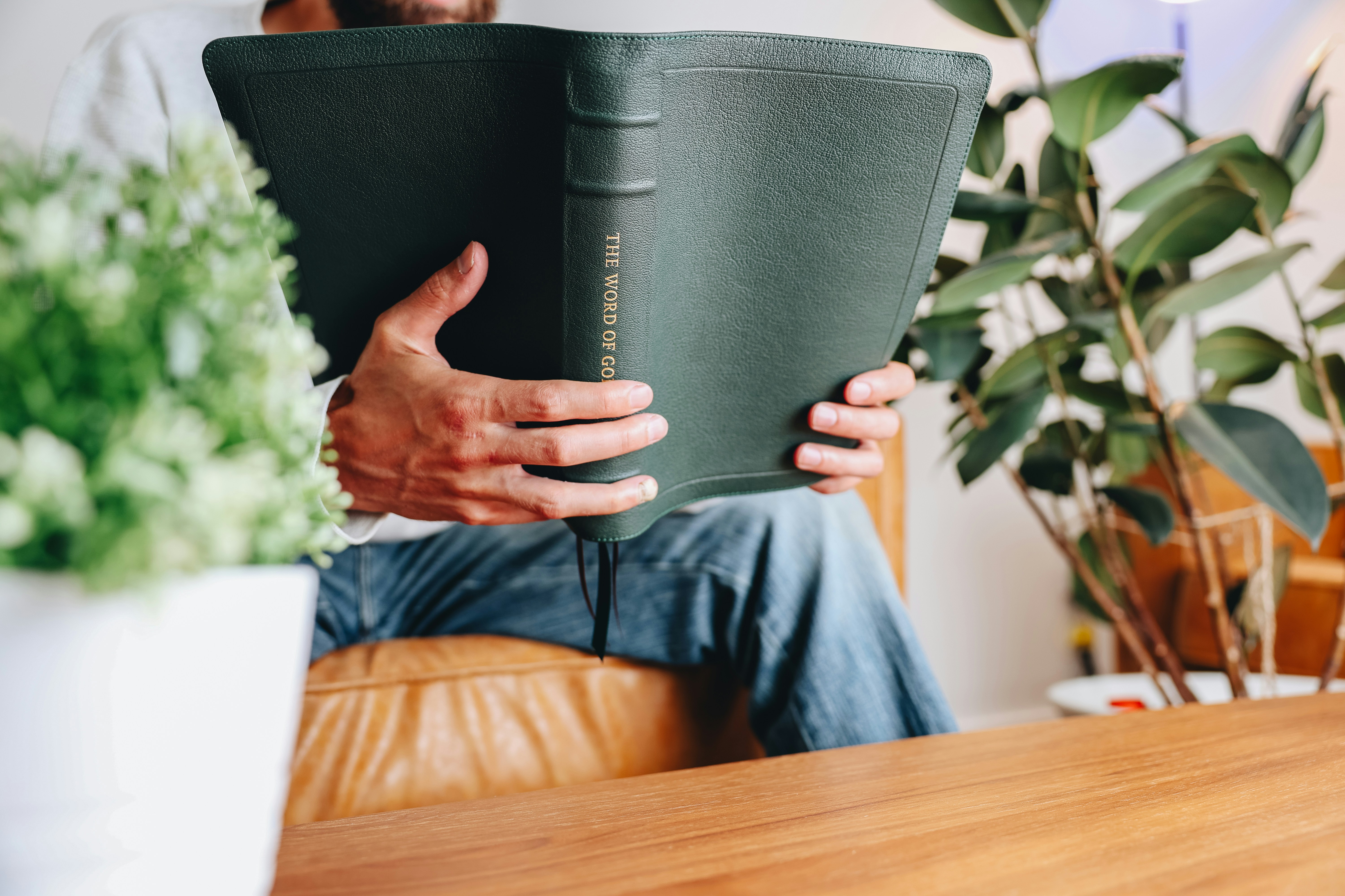 Ein Mann, der auf einer Couch sitzt und ein Buch liest