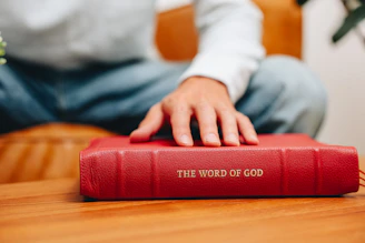 A man sitting at a table with a red book