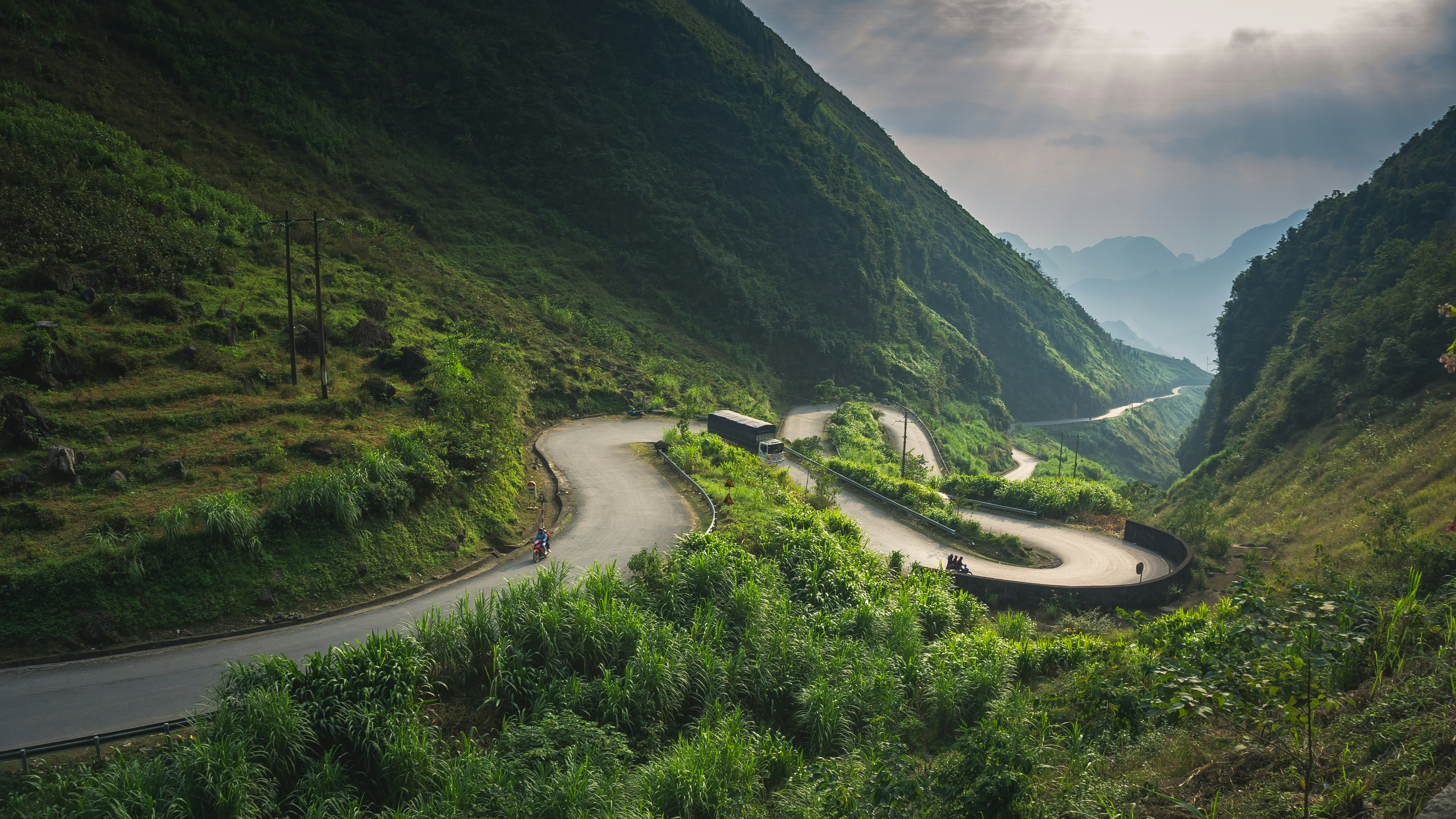A winding road winding through a lush green valley