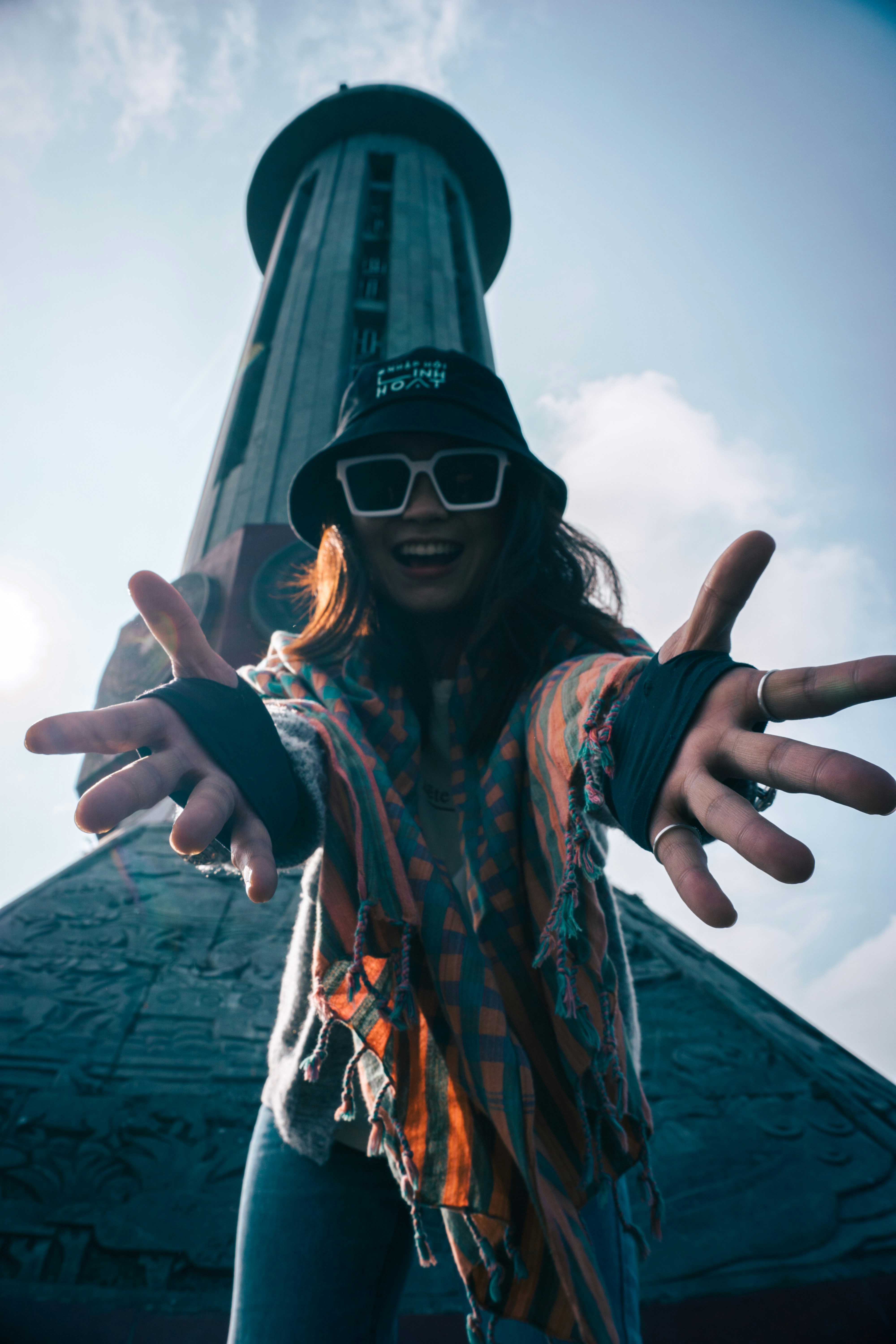 A woman with her arms outstretched in front of a building